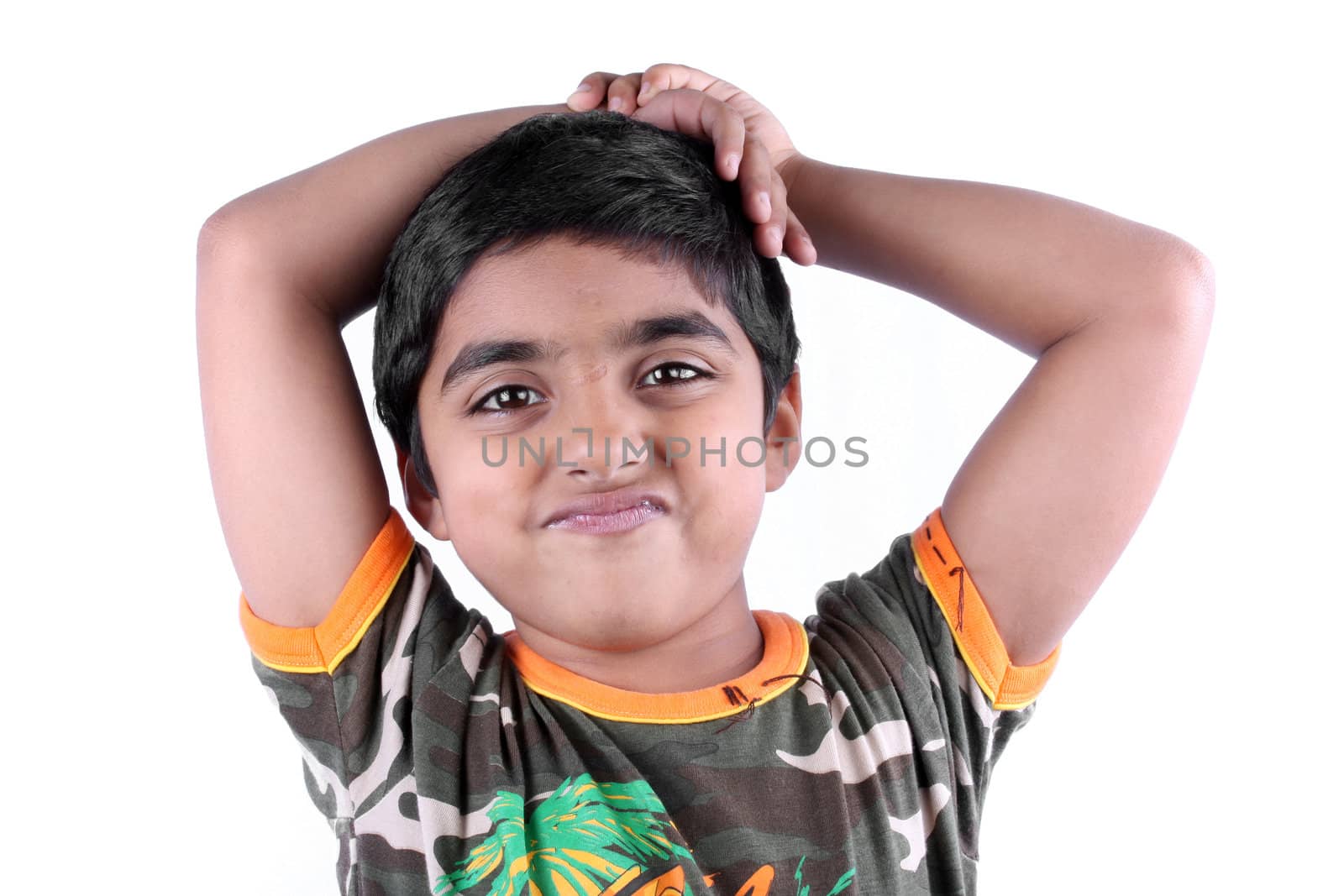 A portrait of a little Indian kid with an 'unsure' expression on his face, on white studio background.