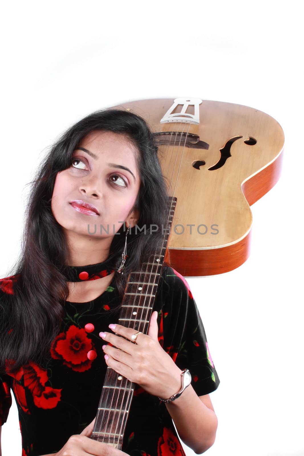 A portrait of a daydreaming Indian guitarist lady, on white studio background.