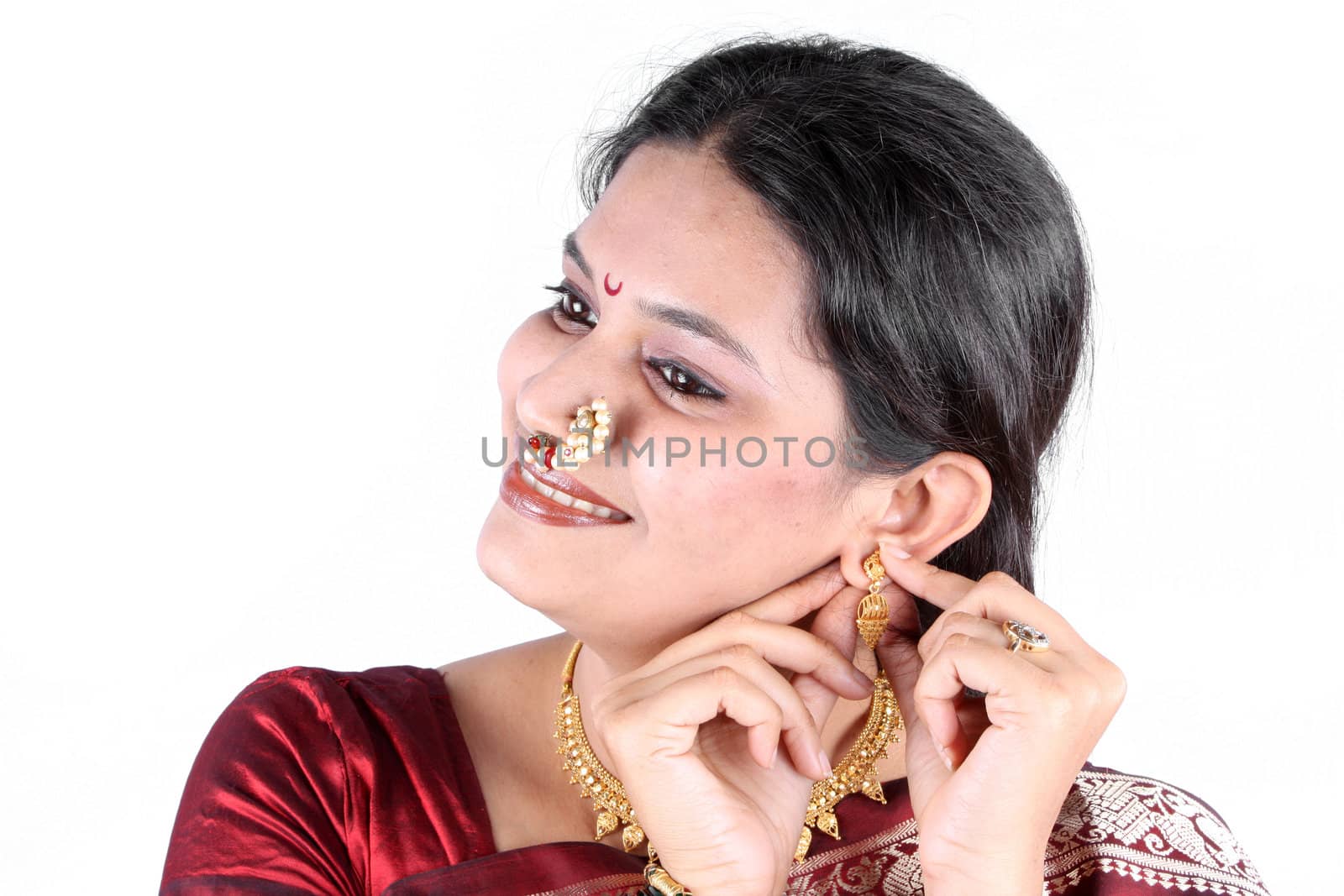 An Indian woman traditionally dressing up with gold jewelery for Diwali festival.