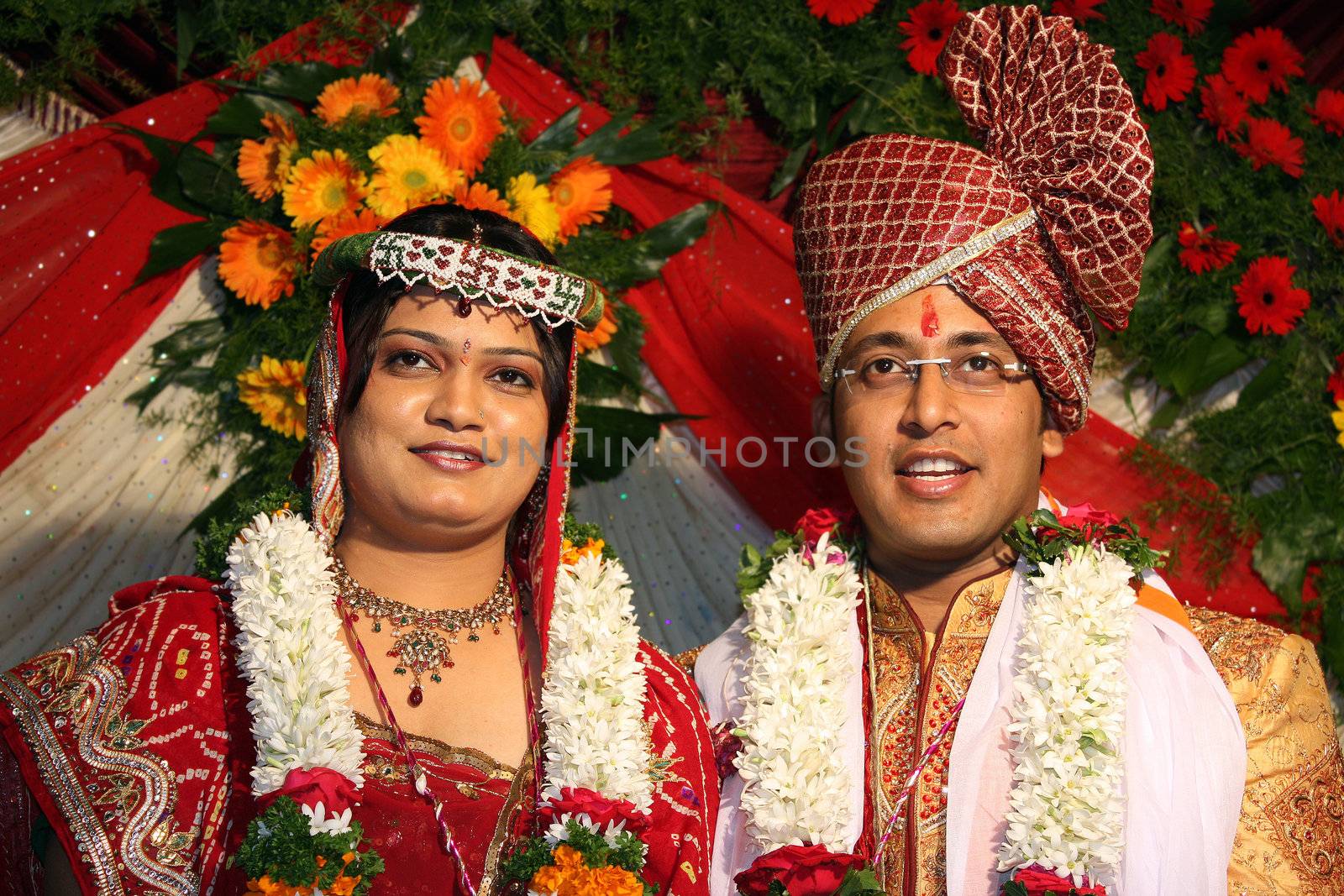 A portrait of an Indian wedding couple in their traditional attire.