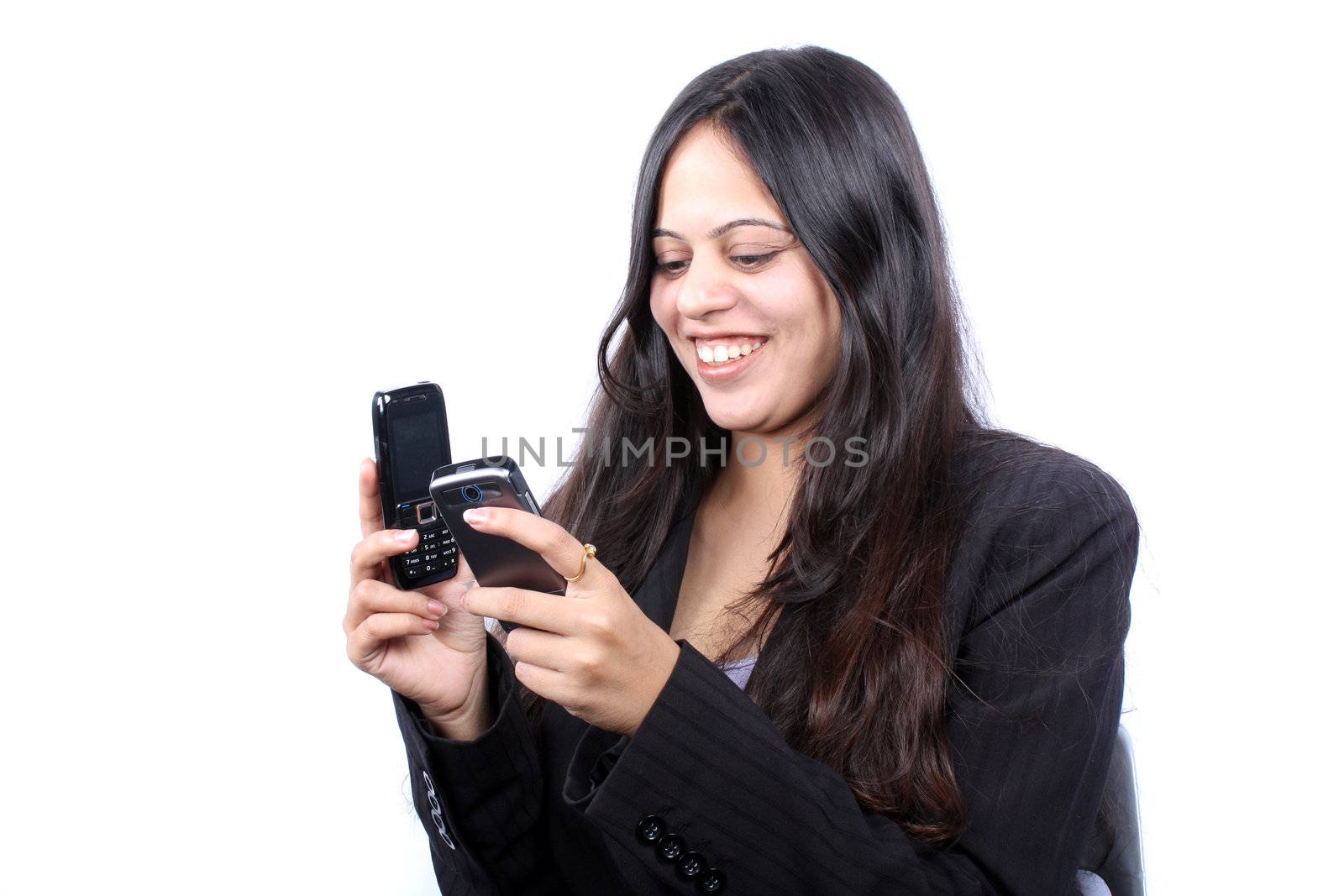 A beautiful Indian businesswoman choosing in two cellphones, on white background.