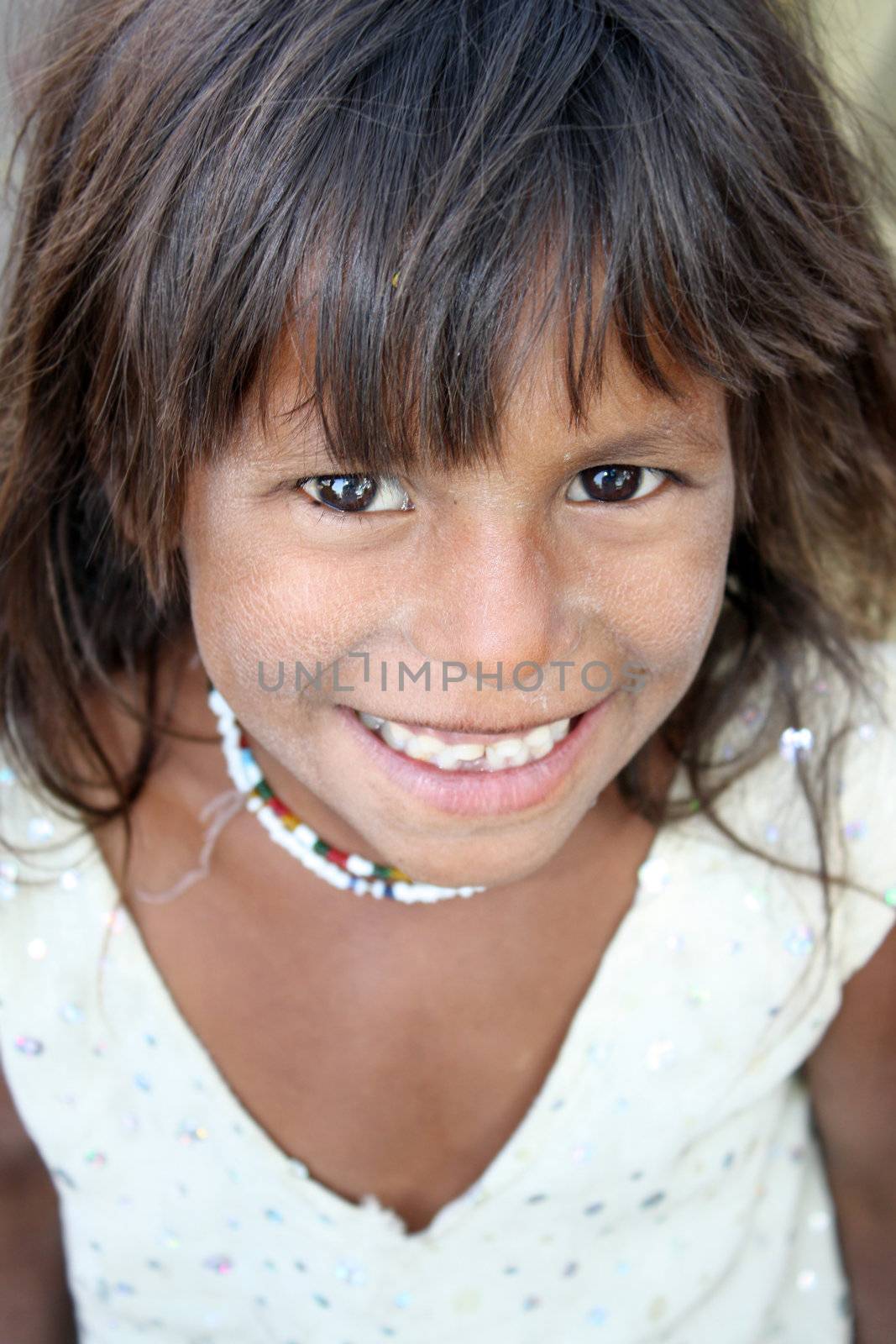 A portrait of a poor Indian beggar girl with a cute smile.