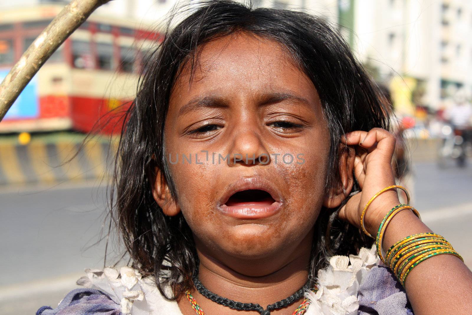 A portrait of a crying beggar girl from India.