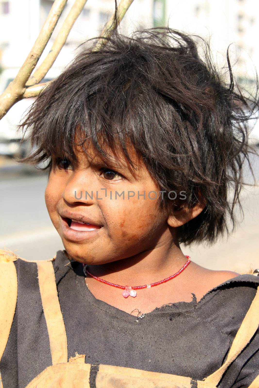 A portrait of a curious looking poor Indian beggar girl.
