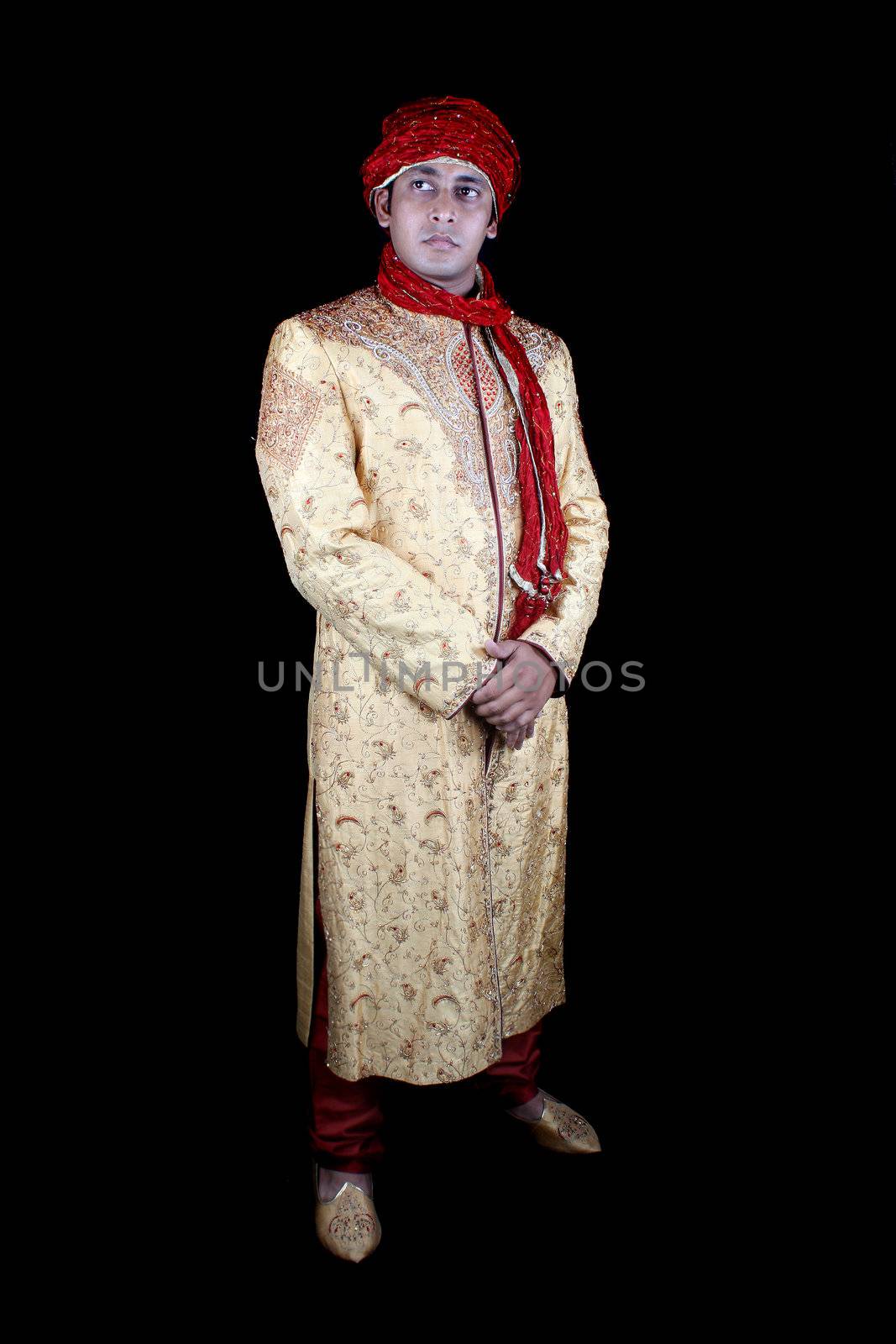An Indian man posed as a Royal Afghan man, on black studio background.