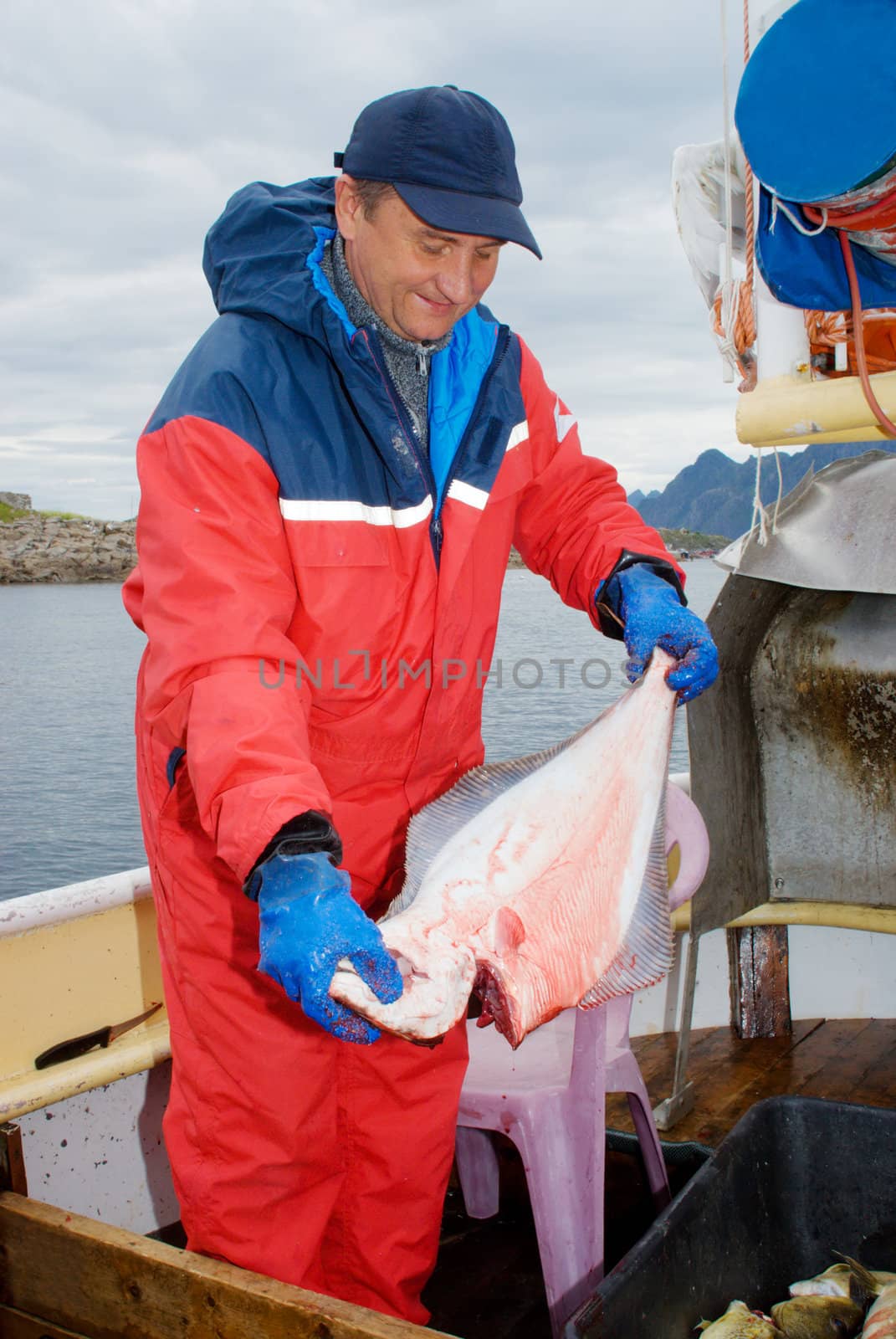 Fisherman with hallibut on the boat at Lofoten islands