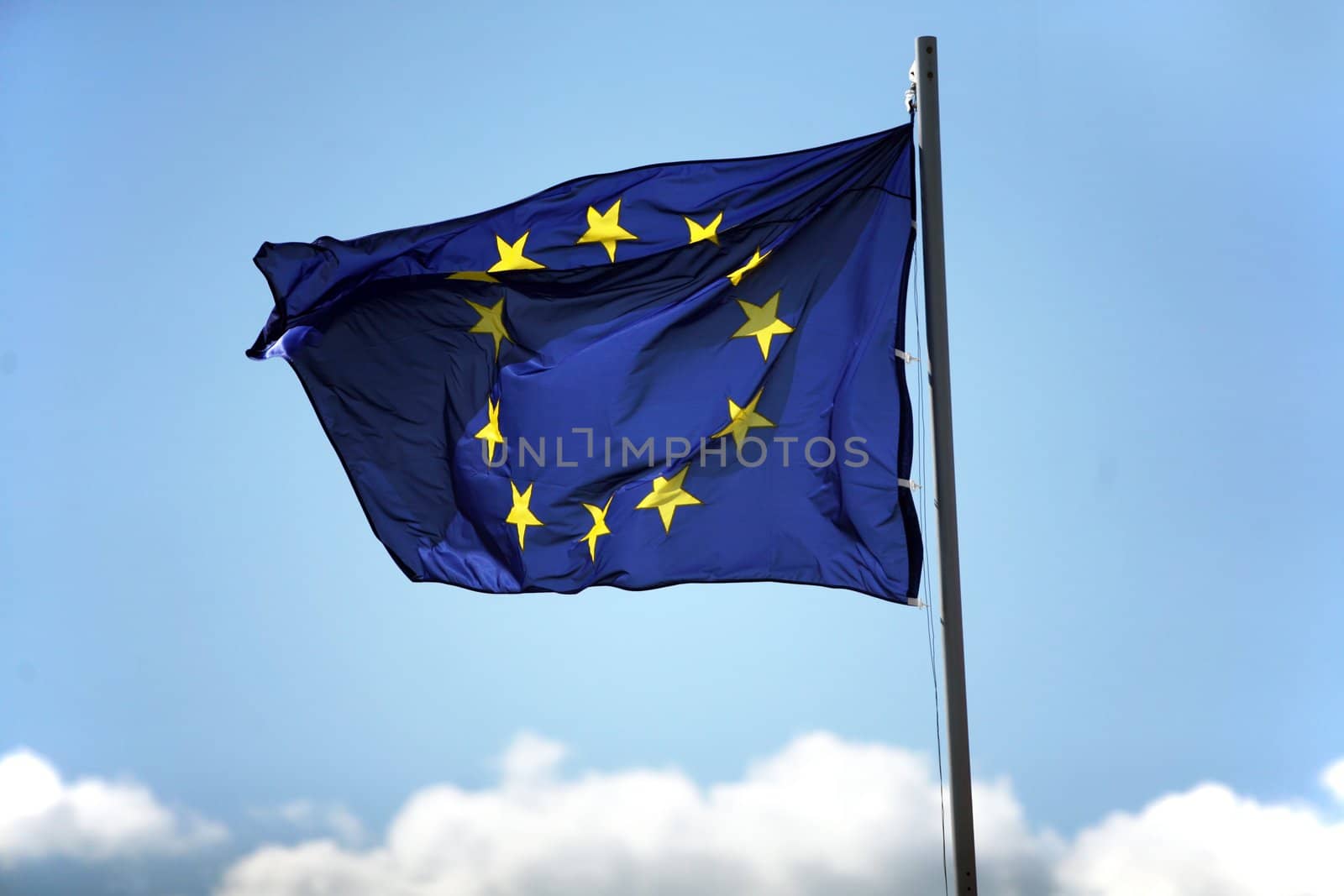 Blue flag of European Union on the cloudy sky
