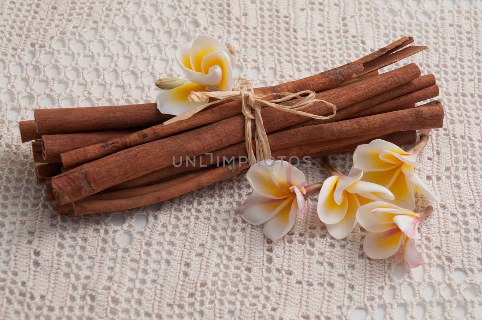 Bunch of cinnamon sticks with almond on the white tablecloth .