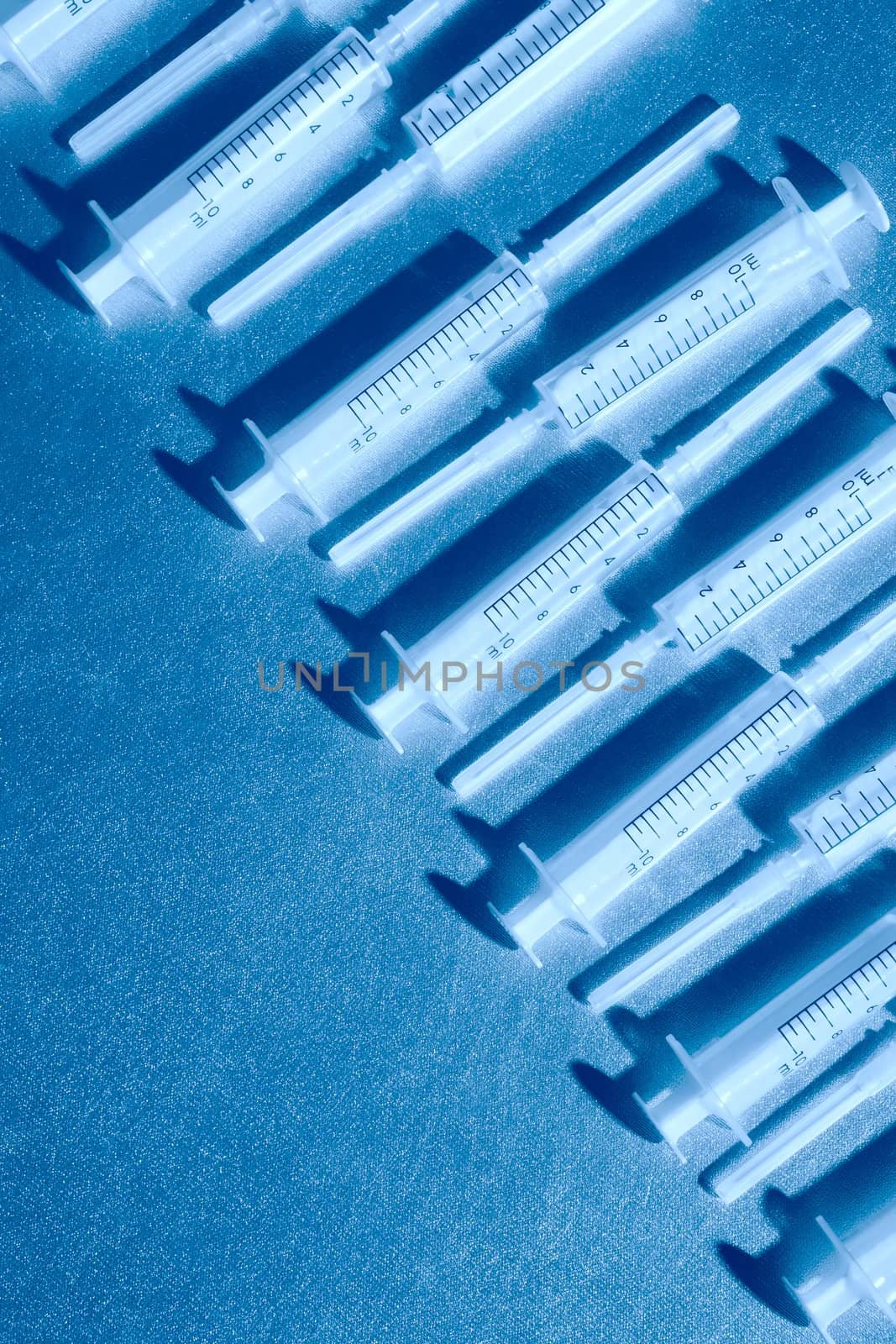 row blue luminous medical syringe with copy-space