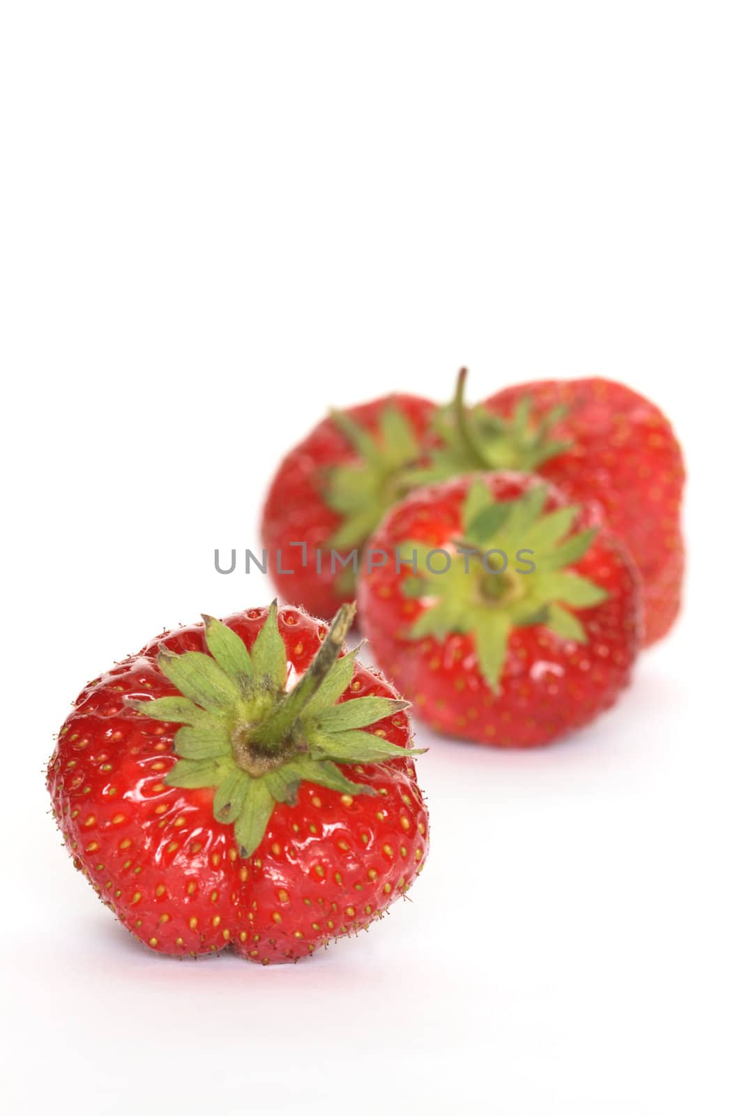 Few red freshness strawberries lying on white background