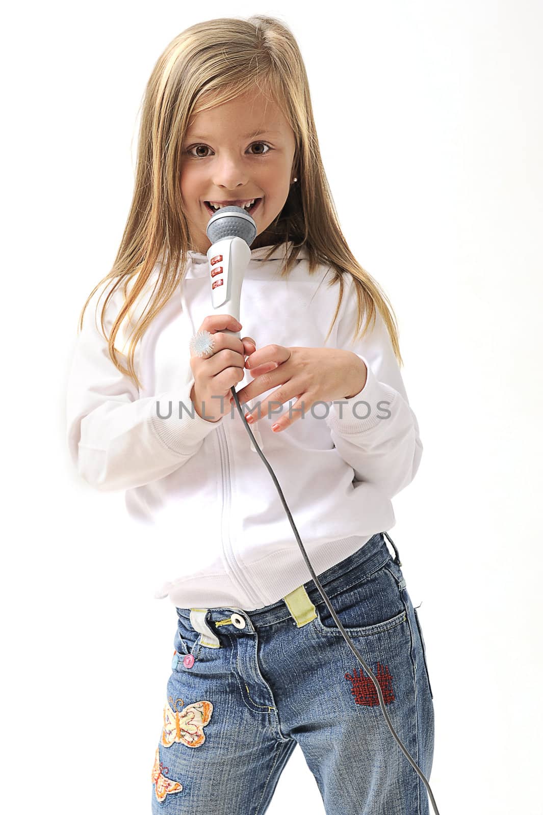 young pretty blond girl singing using a microphone in studio