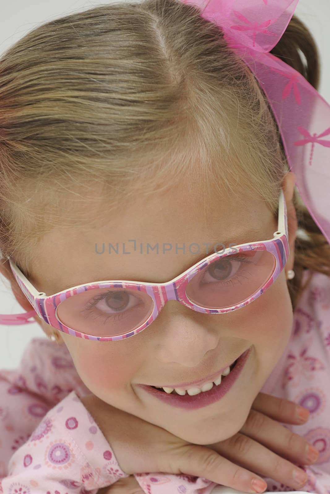 young pretty blond girl with pink sun glasses smiling