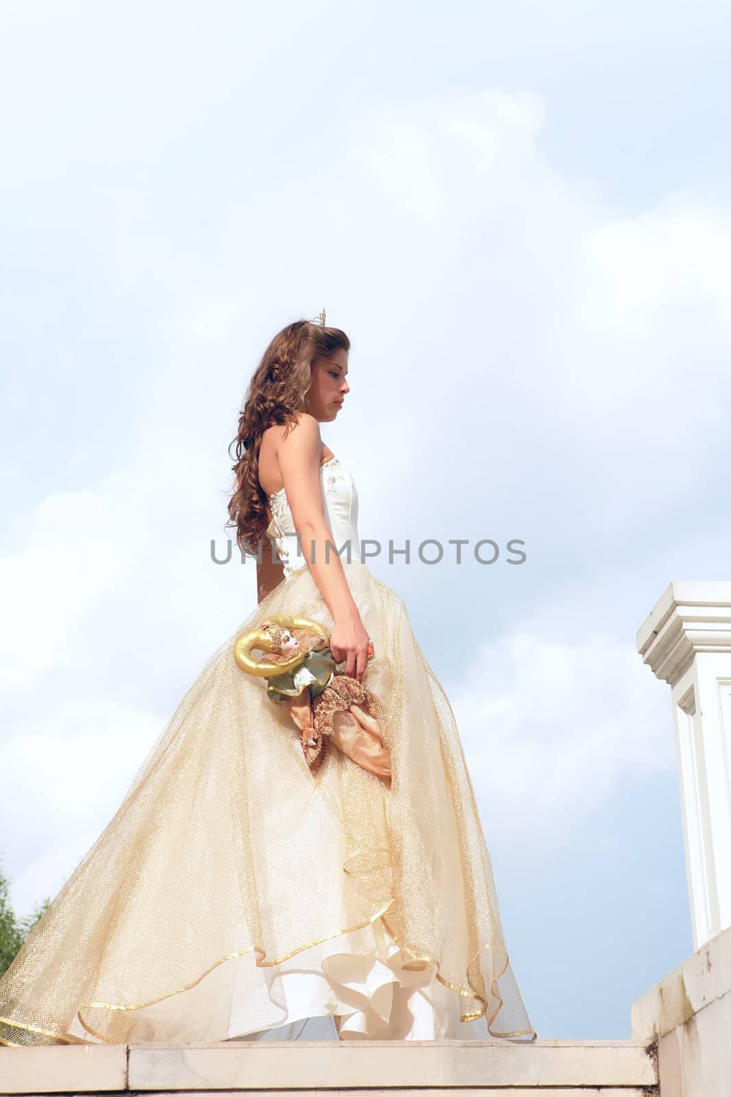 princess in white-golden gown with old loved toy on cloudscape