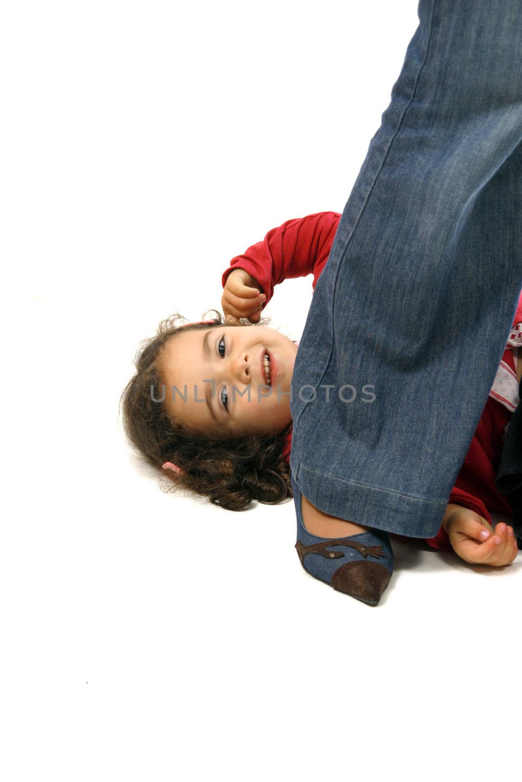 young girl grabbing mums leg