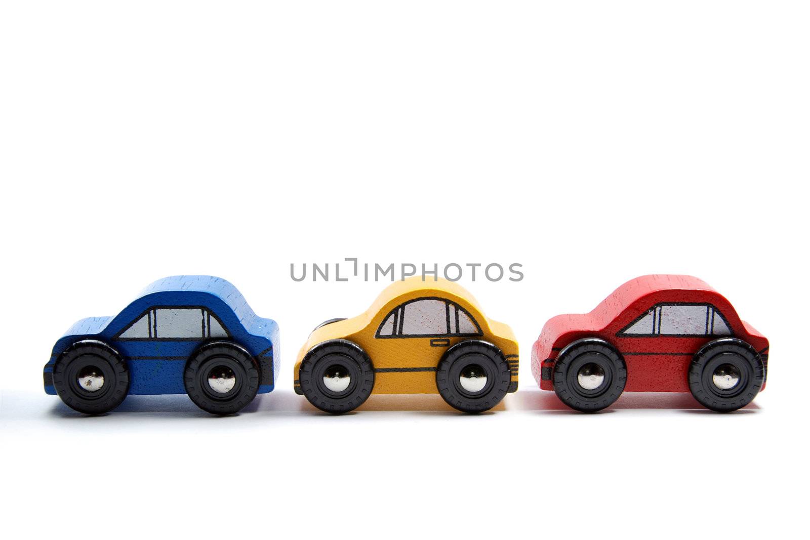 Three wooden toy cars in a row by Gjermund