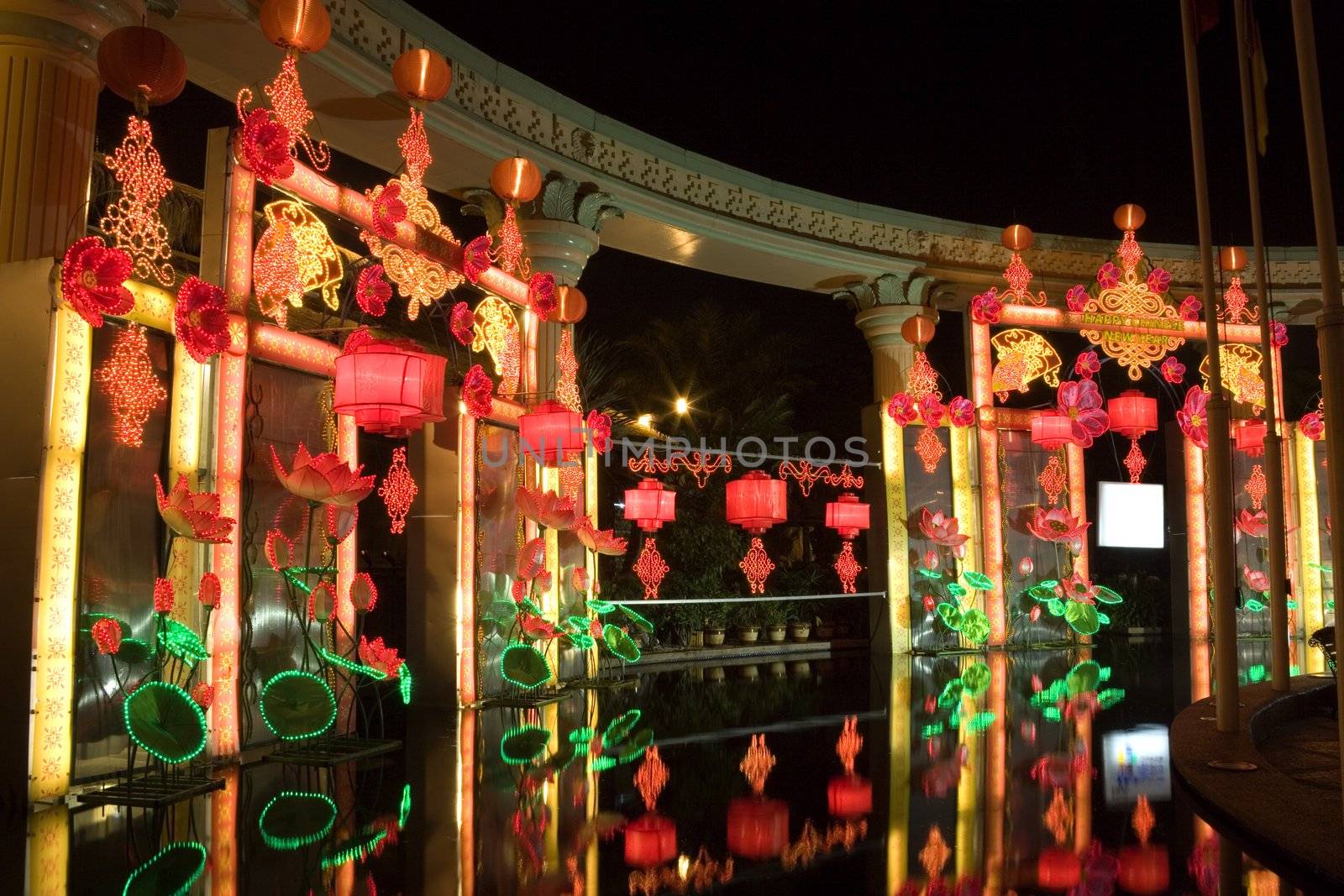 Night image of Chinese New Year lanterns and lights by a pool.