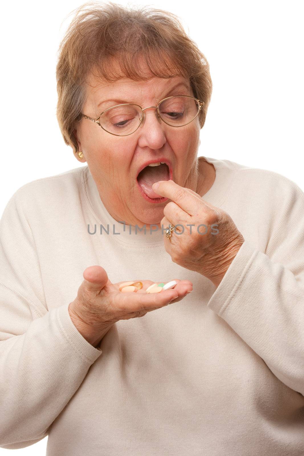 Attractive Senior Woman Taking Pills Isolated on a White Background.