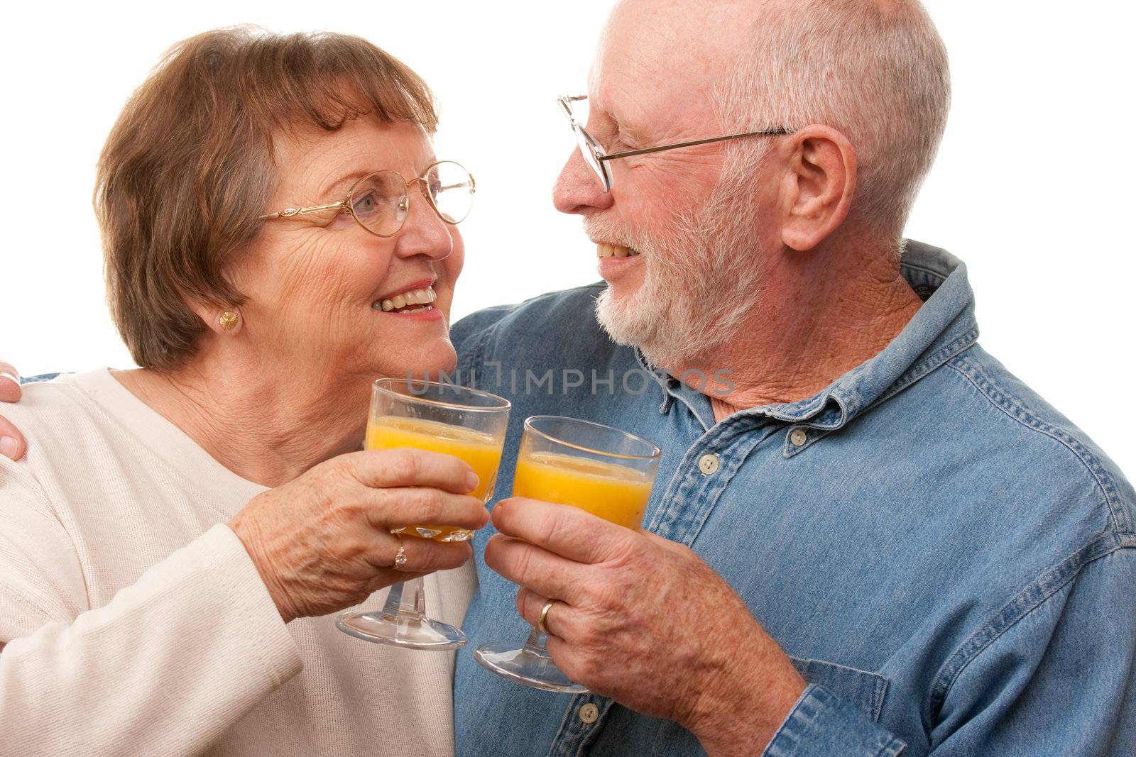 Happy Senior Couple with Glasses of Orange Juice Isolated on a White Background.