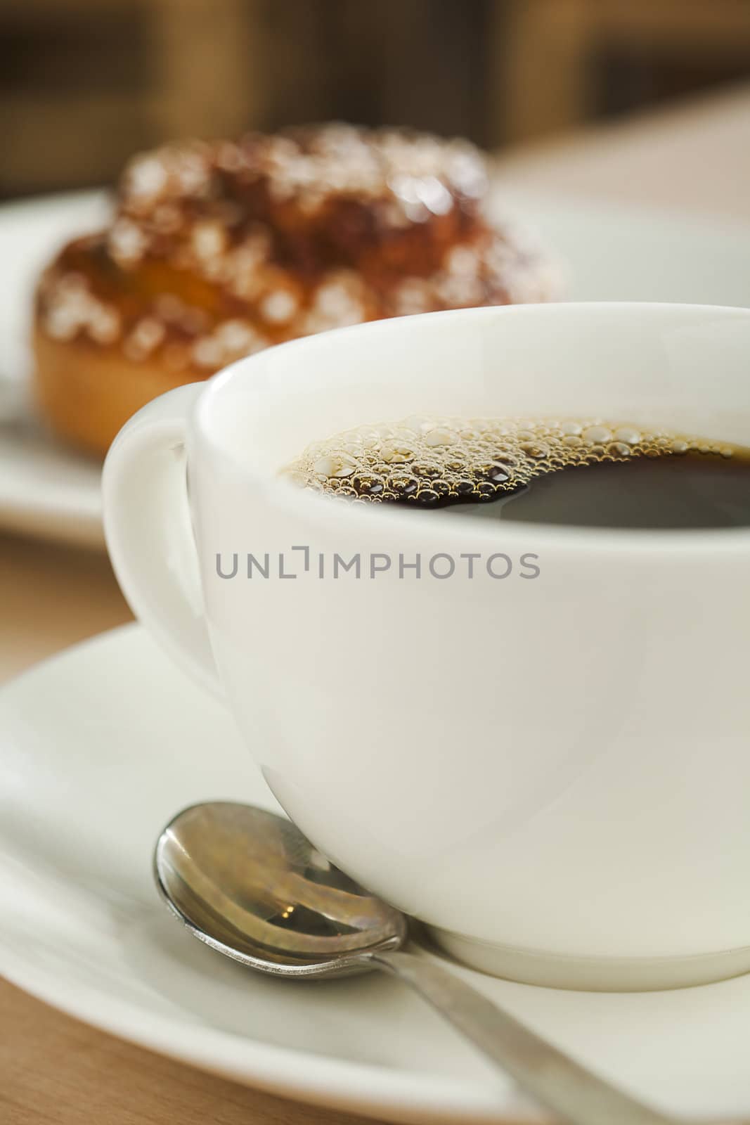 Black coffee cup with dessert bun