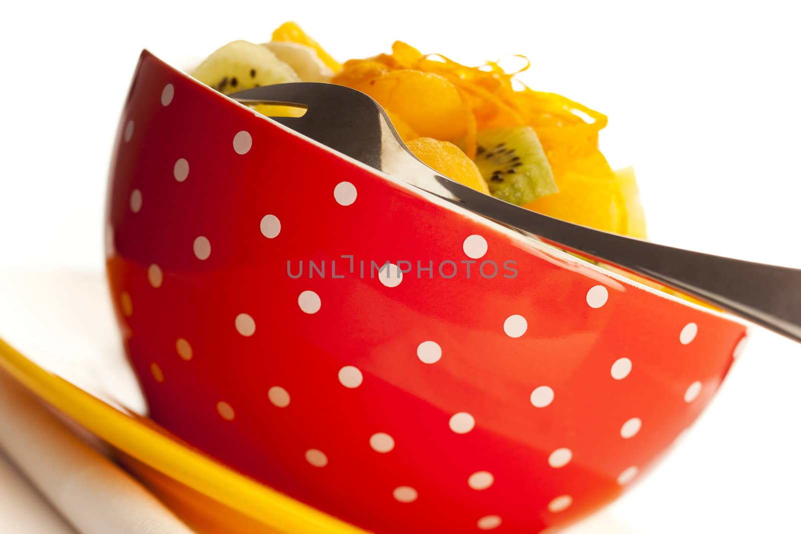 Fruit salad on the white dotted bowl (kiwi, orange, pinapple, banana etc).