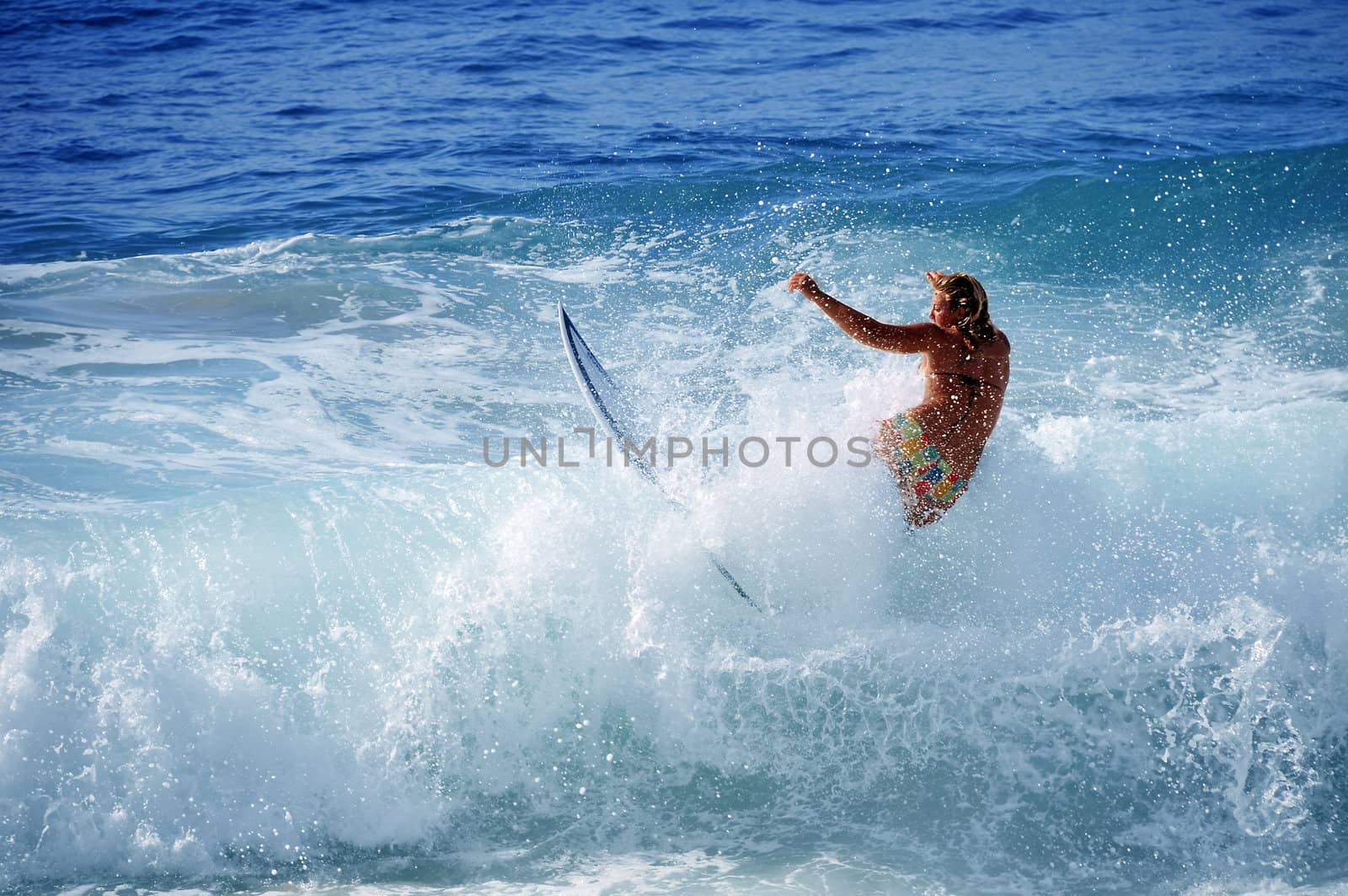 Hawaii, Kauai - Oct 21, 2008: Surfer girl Malia Rimavicus crashes into a wave at training