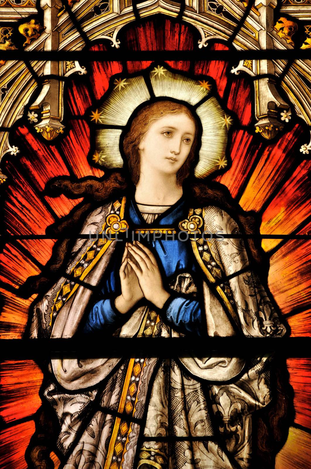 Stained Glass window of St Mary in contemplative prayer