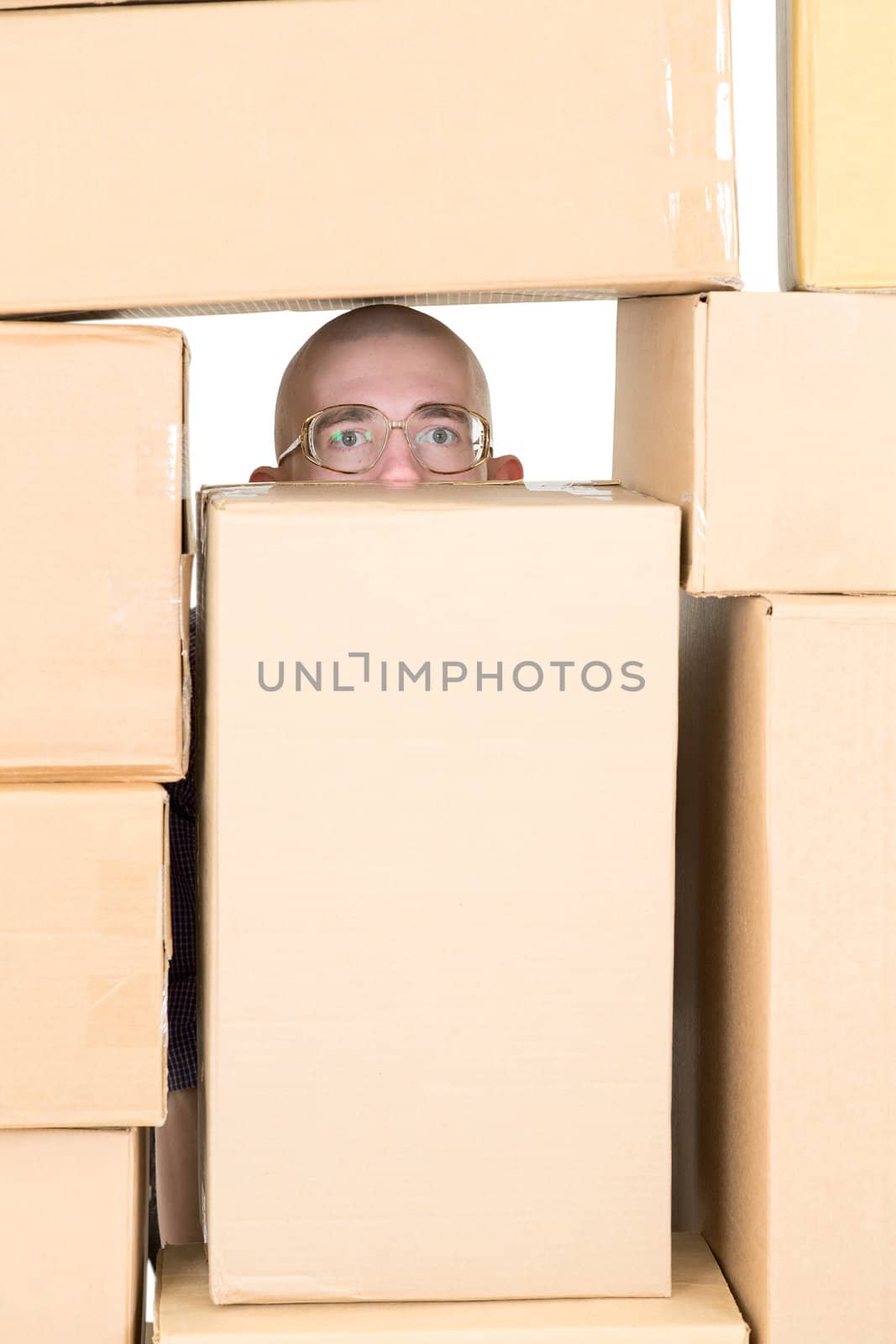 Man looking through window in pile of cardboard boxes