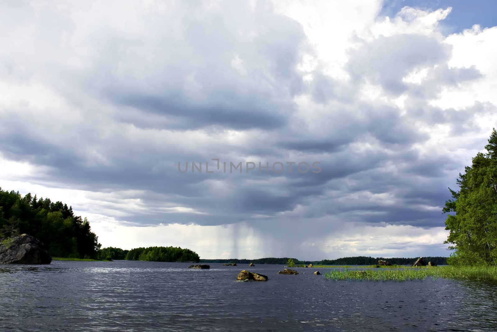Cloudy sky with rain falling on lake