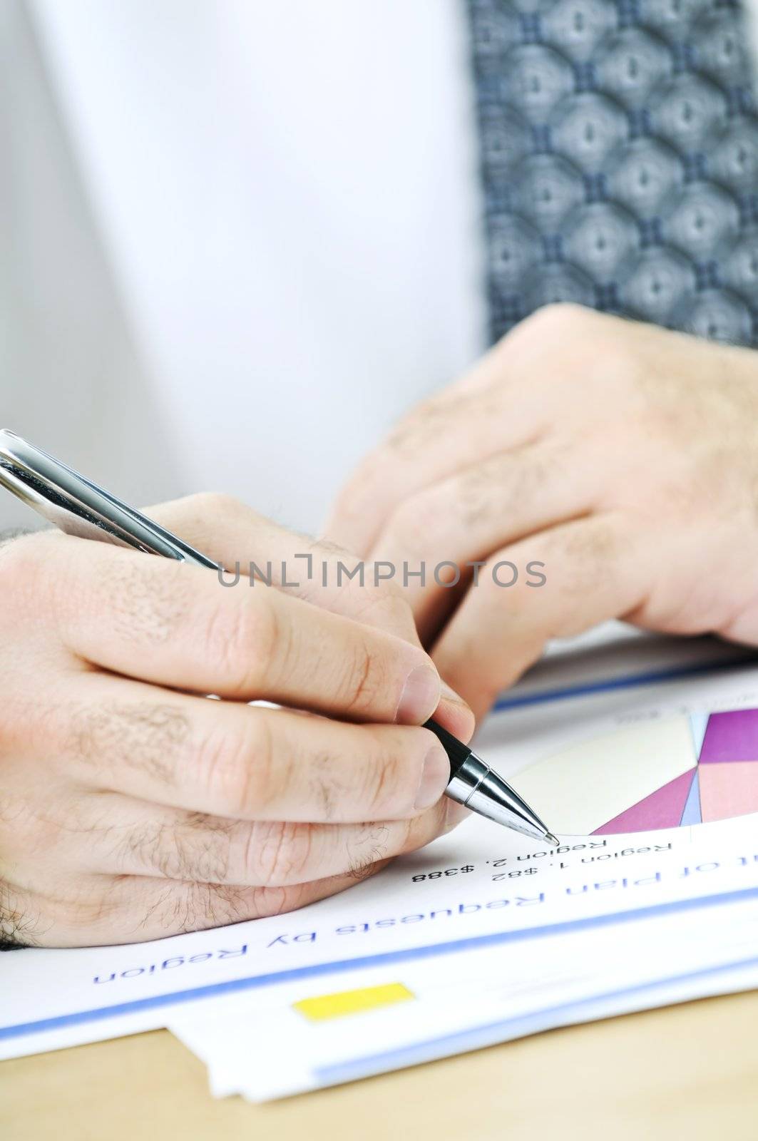 Office worker reviewing generic presentation charts and reports