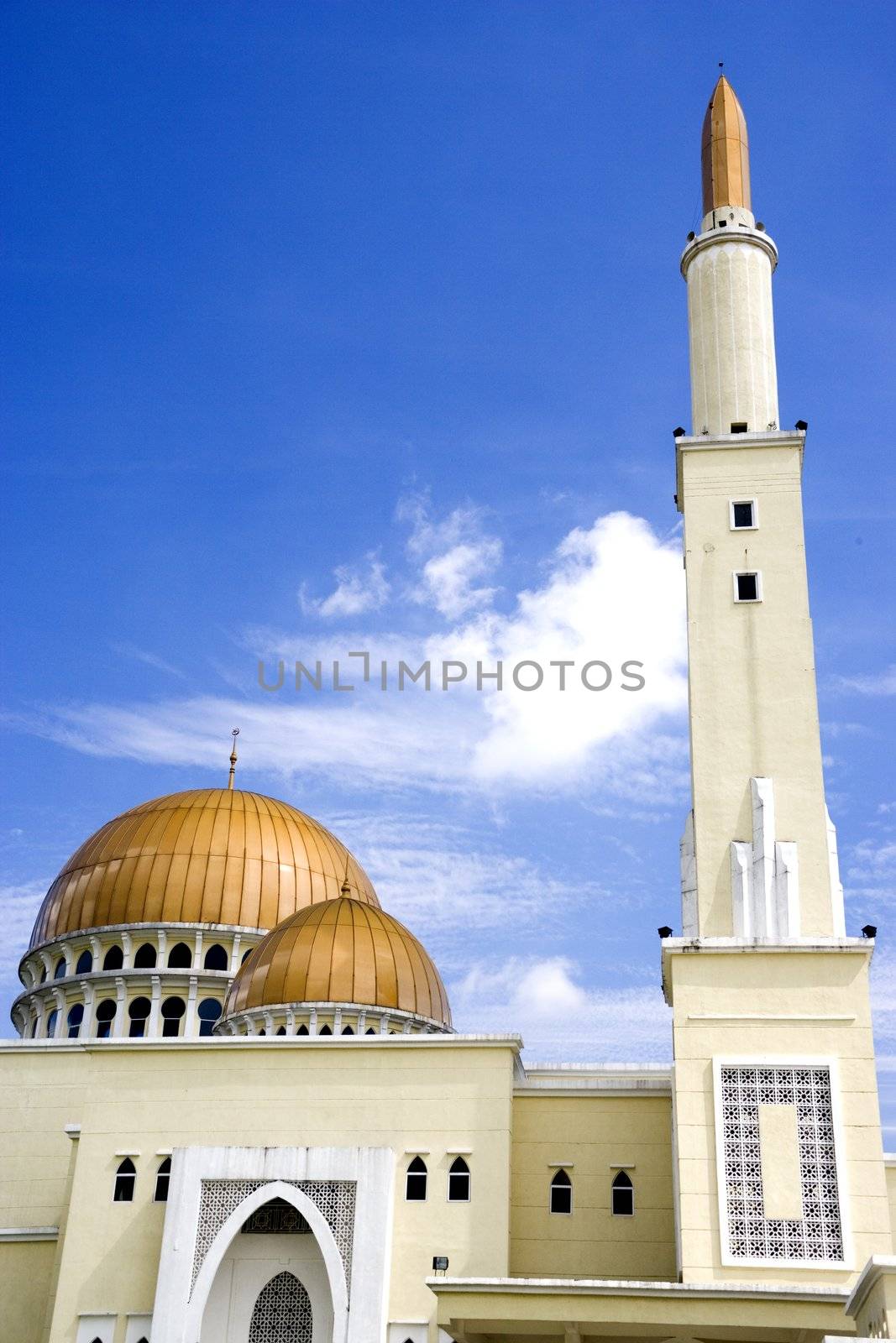 Mosque with gold coloured domes and minaret in Malaysia.