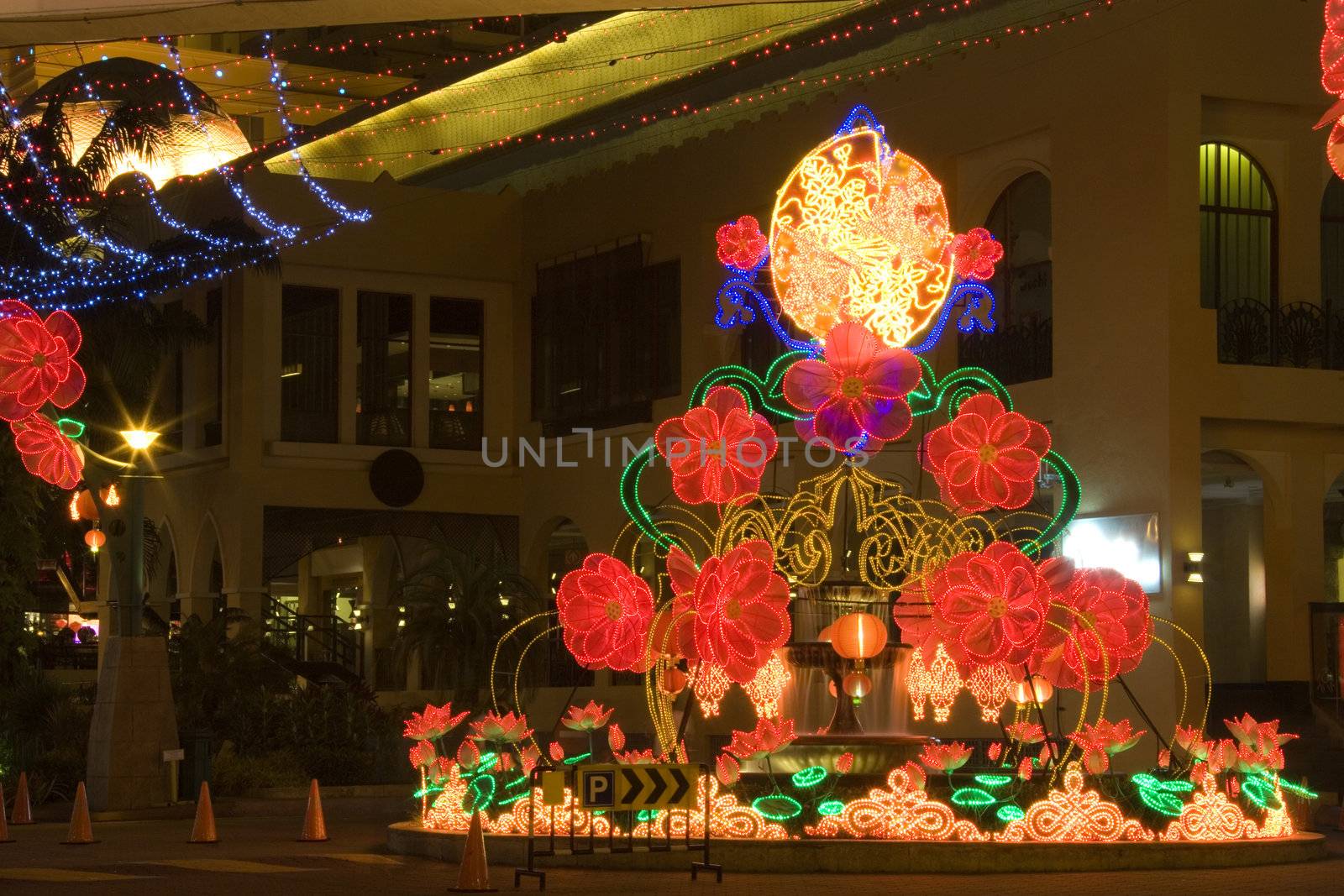 Night image of a street round-about decorated with lanterns and lights during Chinese New Year in Malaysia.