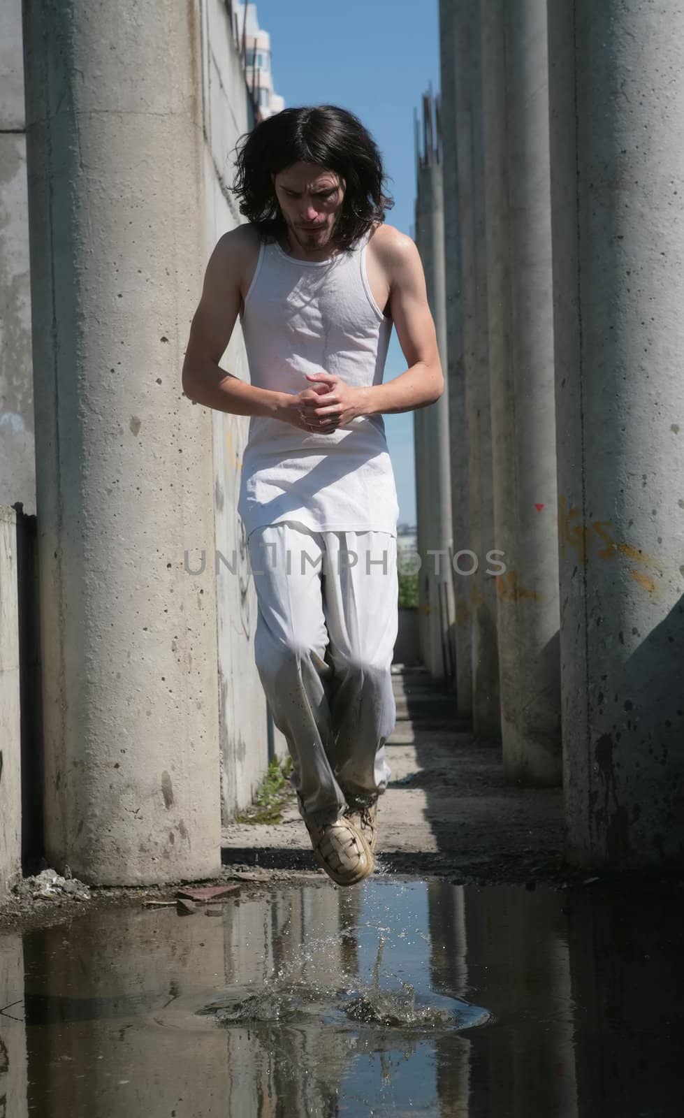man in white cloth and with long hair levitation above water