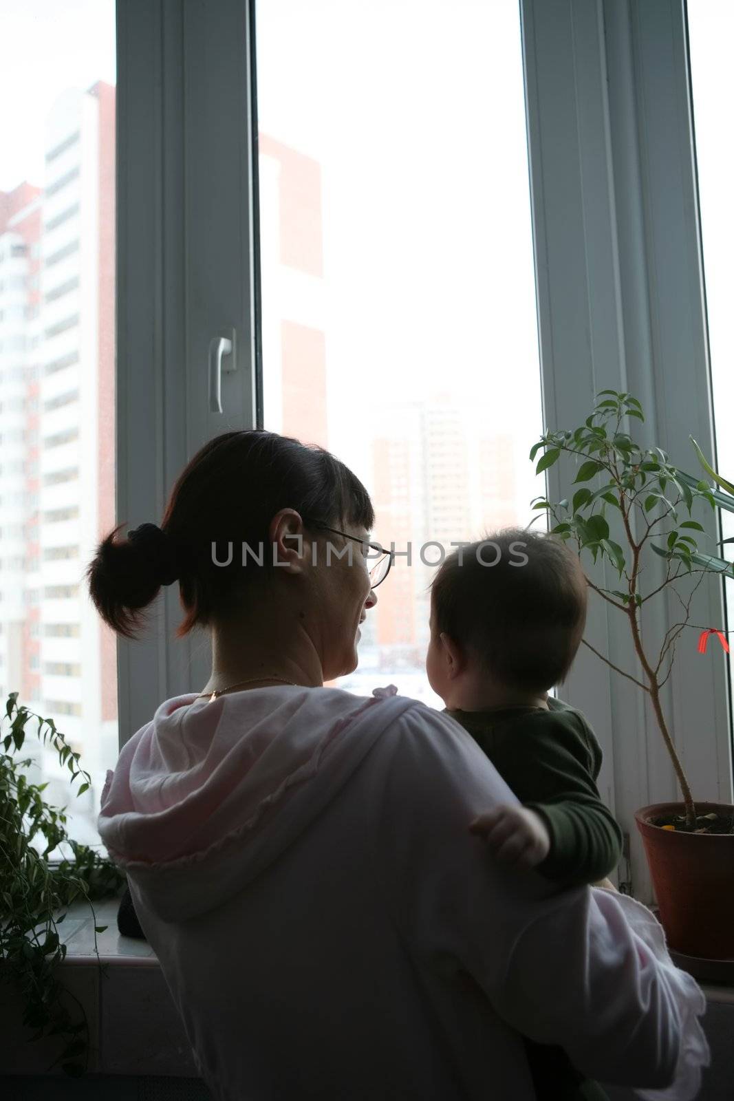 mother and small son beside it on hand near window