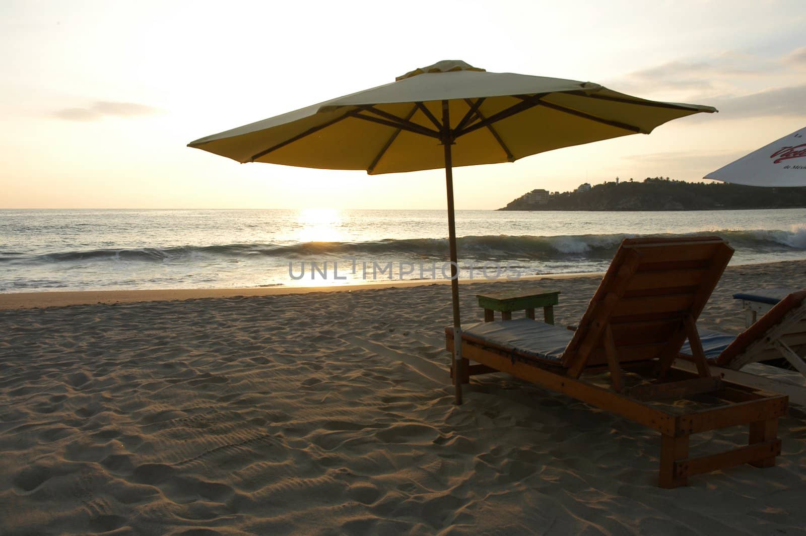 Silhouette of beach umbrellat during sunset over the beach of Puerto Escondido