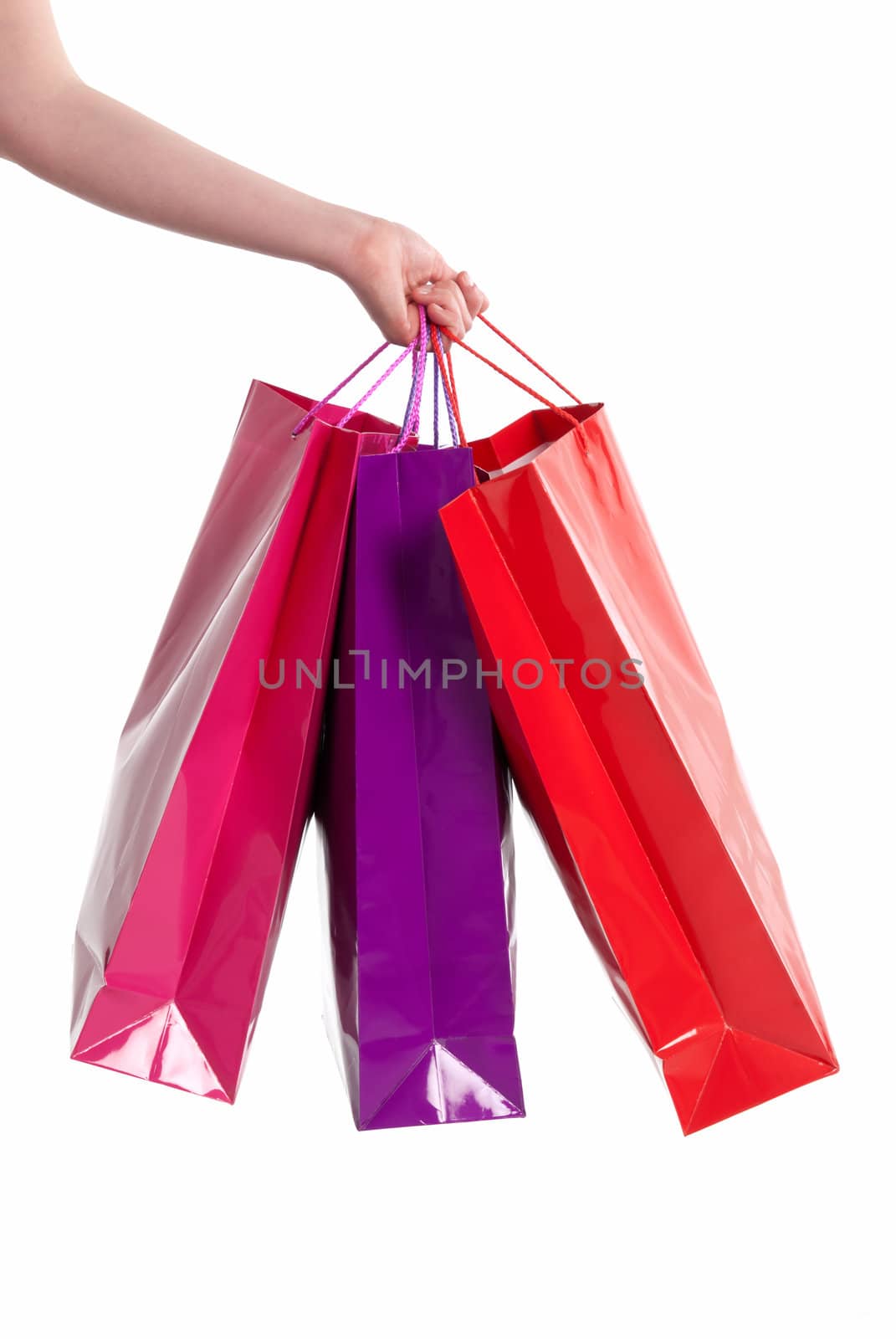 Female hand holding shopping bags isolated on white background by dgmata