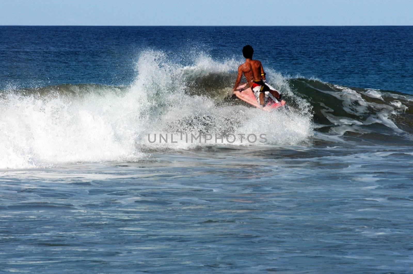 Surfer lying on  surf on the small wave, Puerto Escondido, Mexico