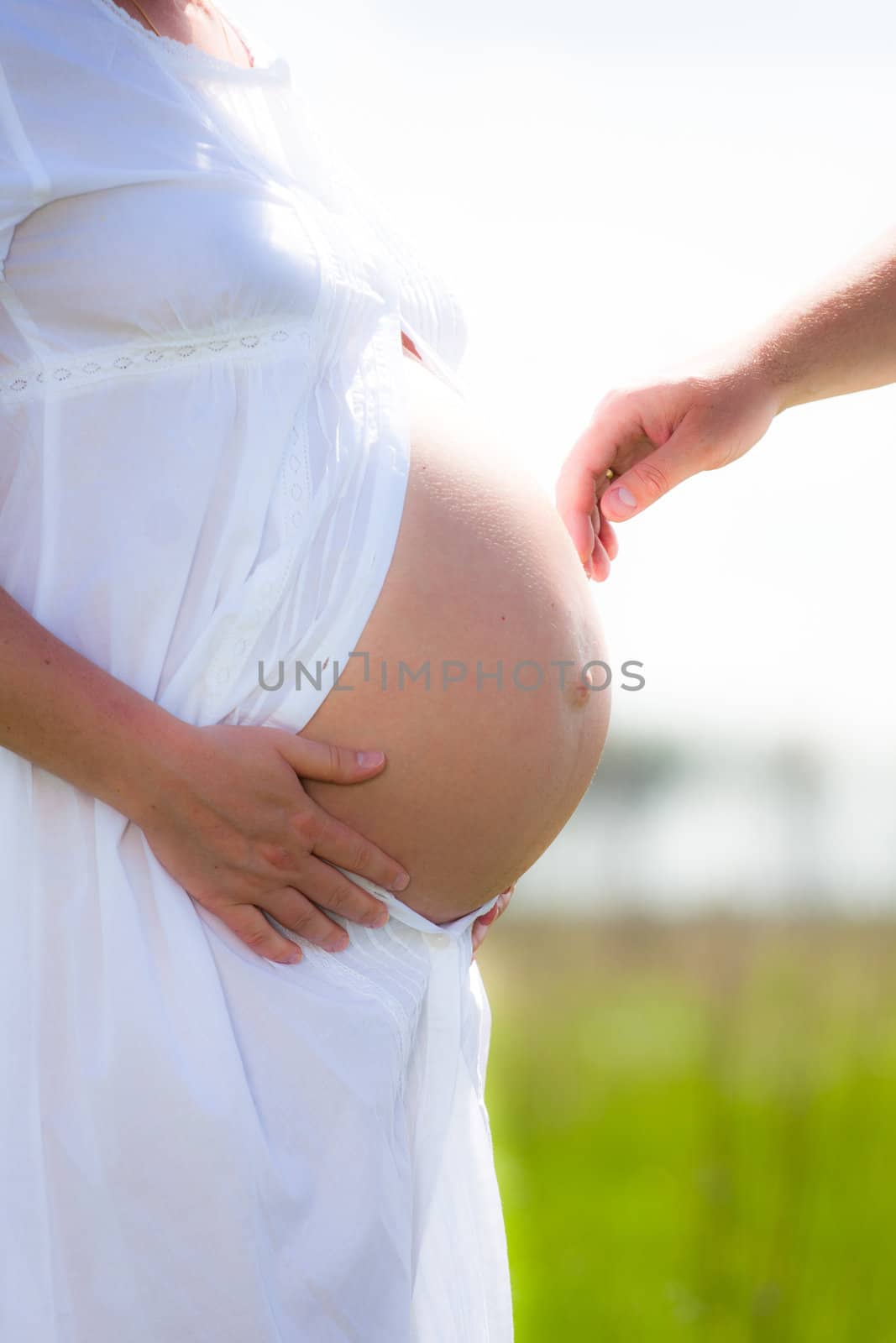 Hand touching stomach of pregnant women
