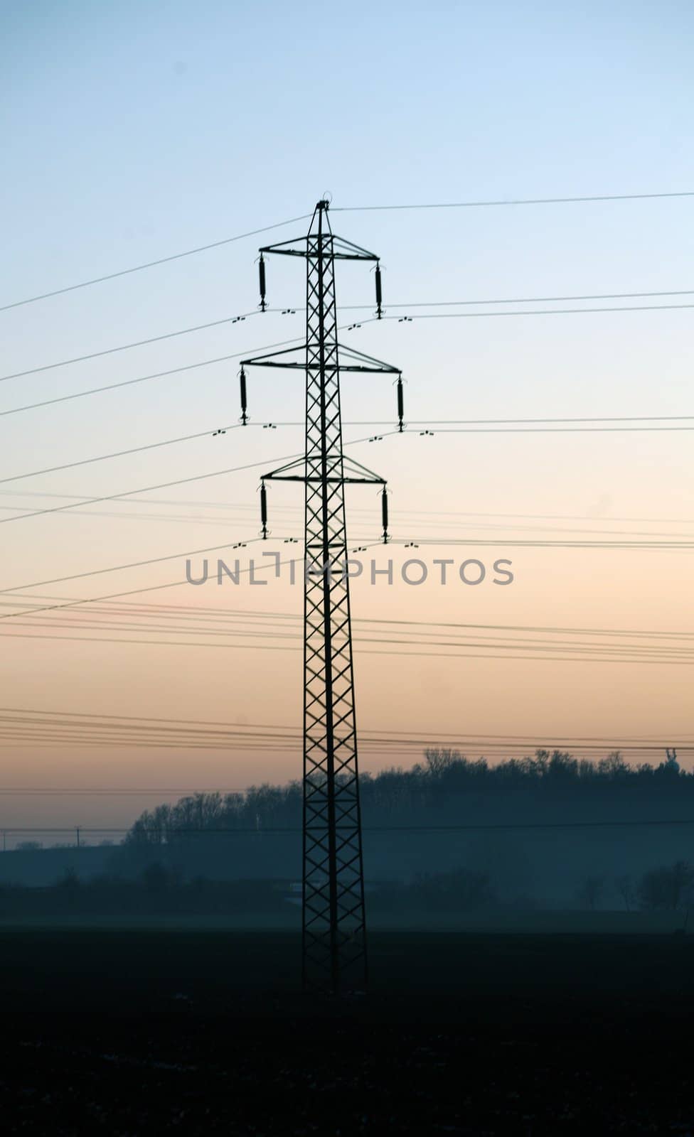 Landscaoe with silhouette of electric pylon during sunset