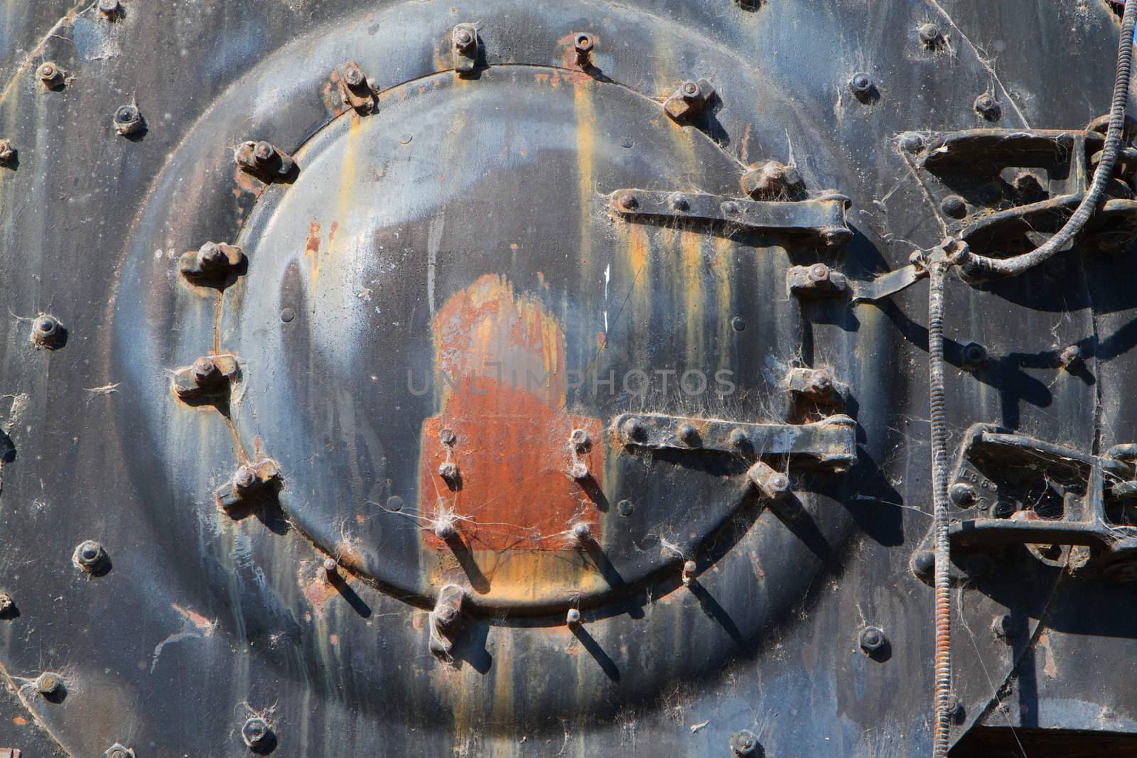 Rusted brightly lit boiler cap on front end of railroad engine