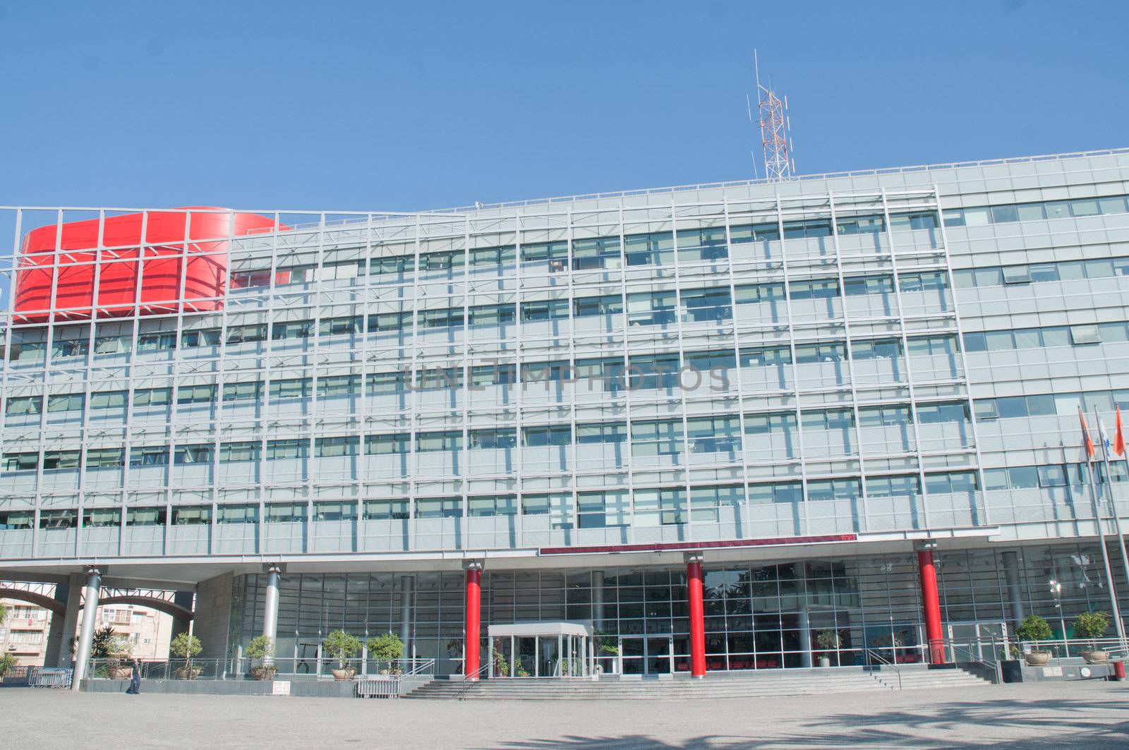 Exterior of modern high rise office buildings with glass windows and blue sky background.

