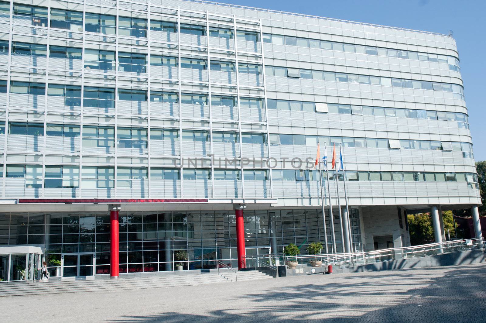 Exterior of modern high rise office buildings with glass windows and blue sky background.

