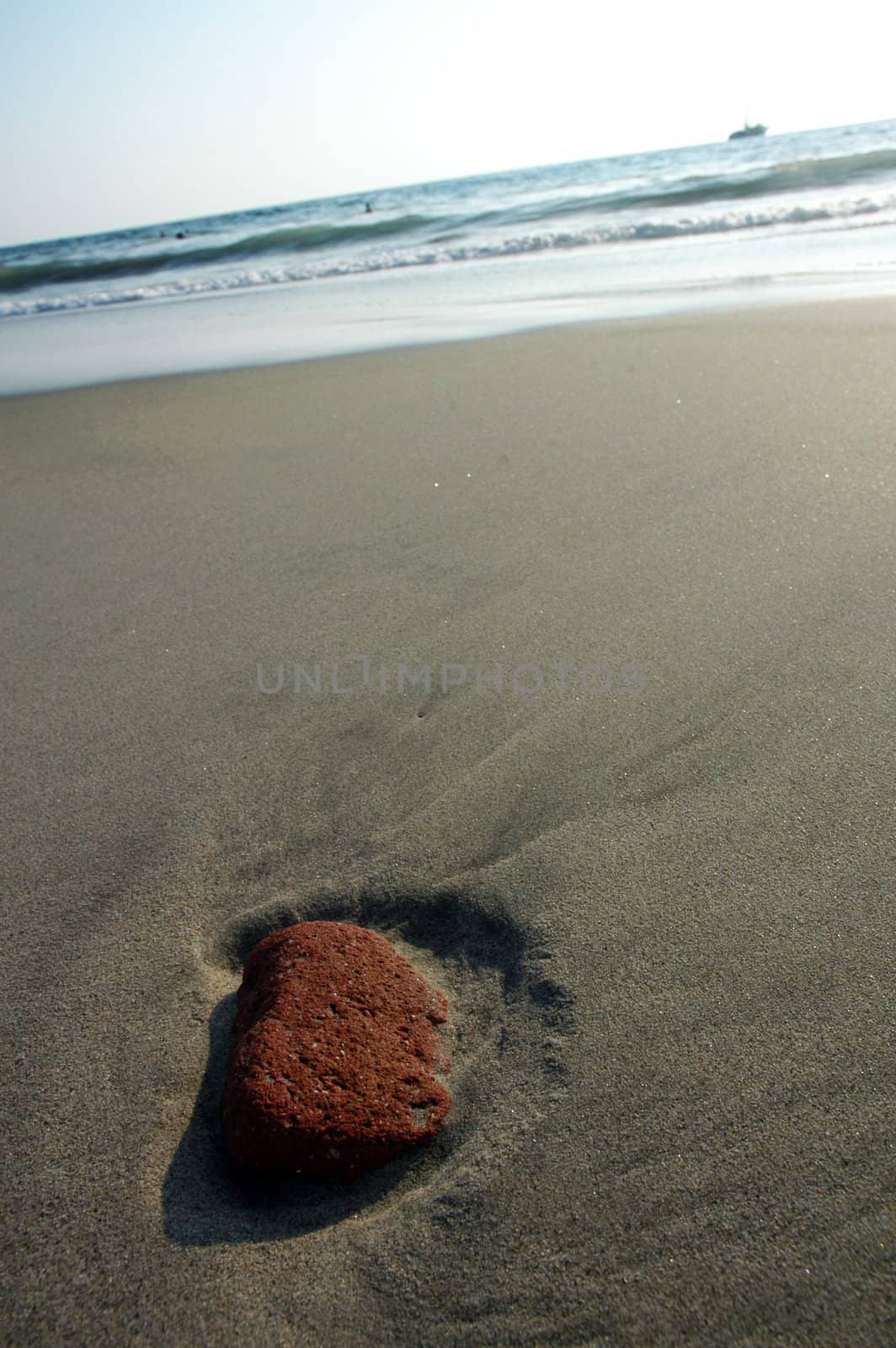 Red stone in the sand after ebb in Puerto Escondido, Mexico by haak78