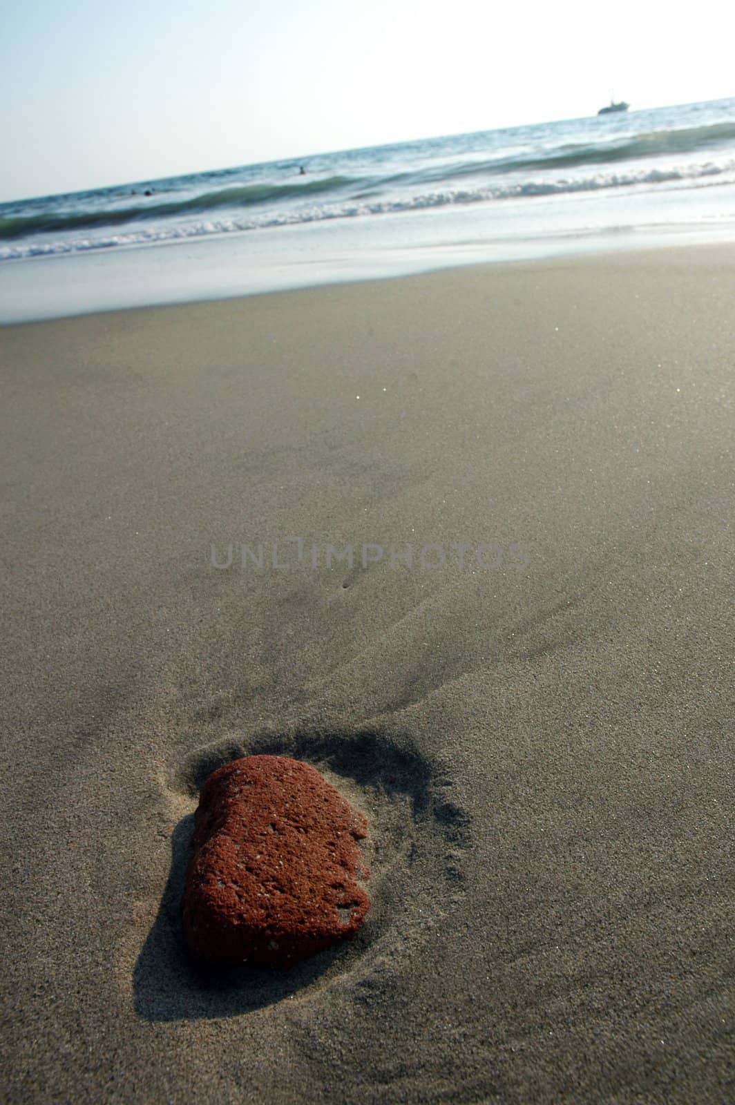 Red stone in the sand after ebb in Puerto Escondido, Mexico