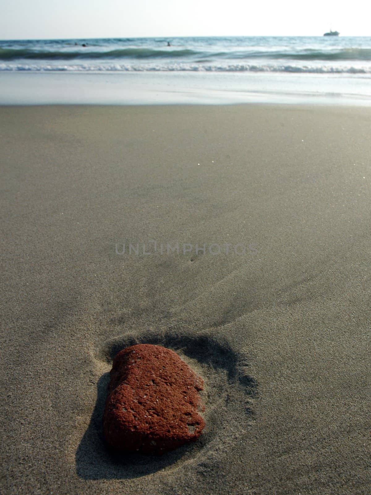 Red stone in the sand after ebb in Puerto Escondido, Mexico