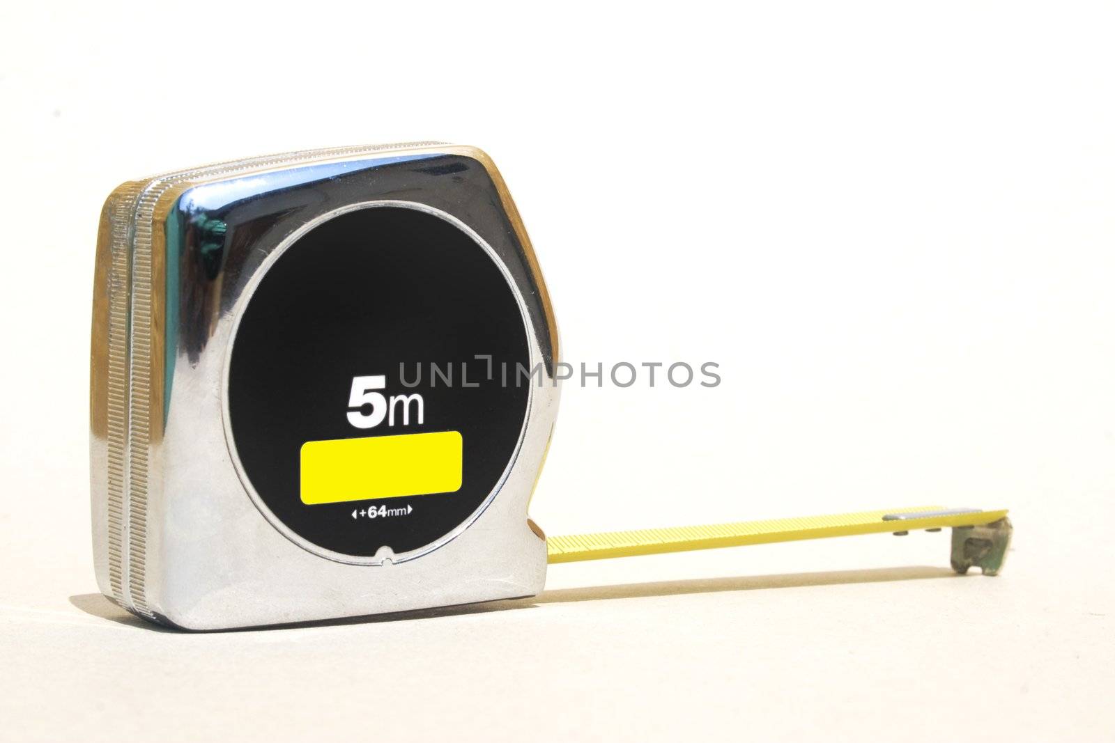 Silver retractable tape ruler against white background