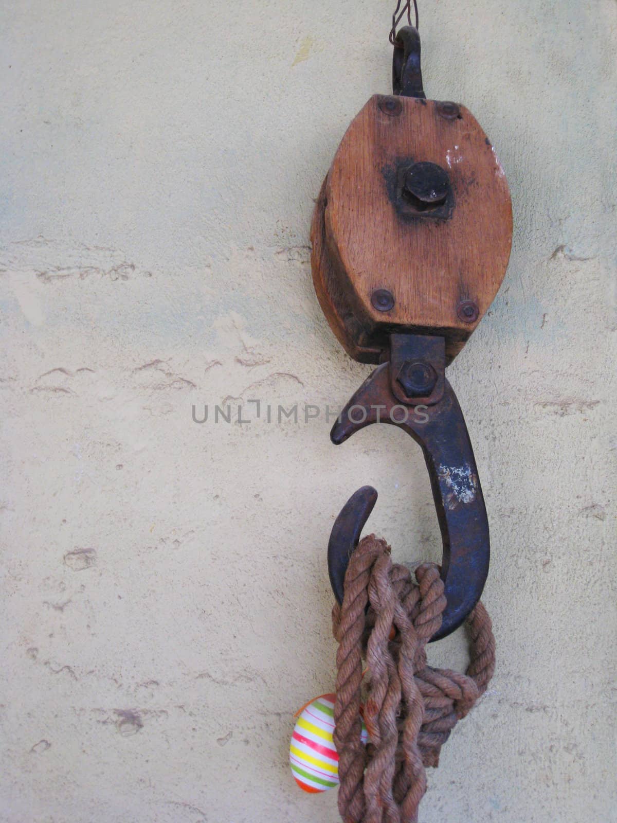 Old block hook hanging on white wall