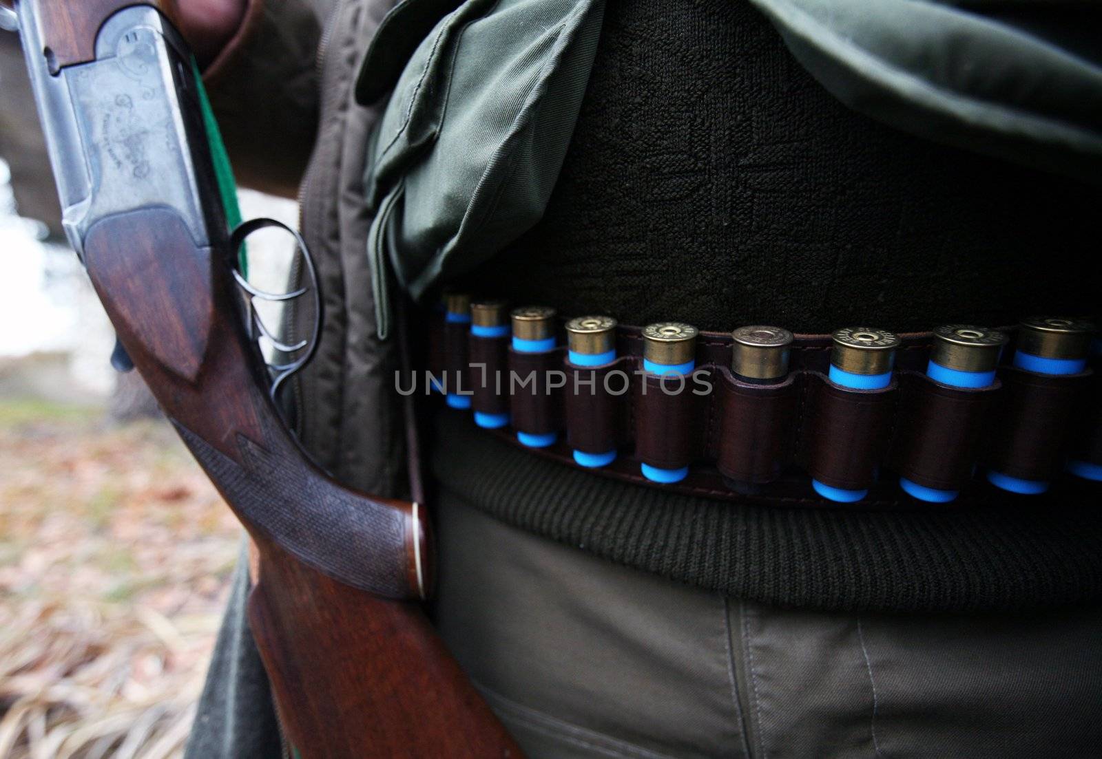 Hunter with ammunition belt around his waist and gun