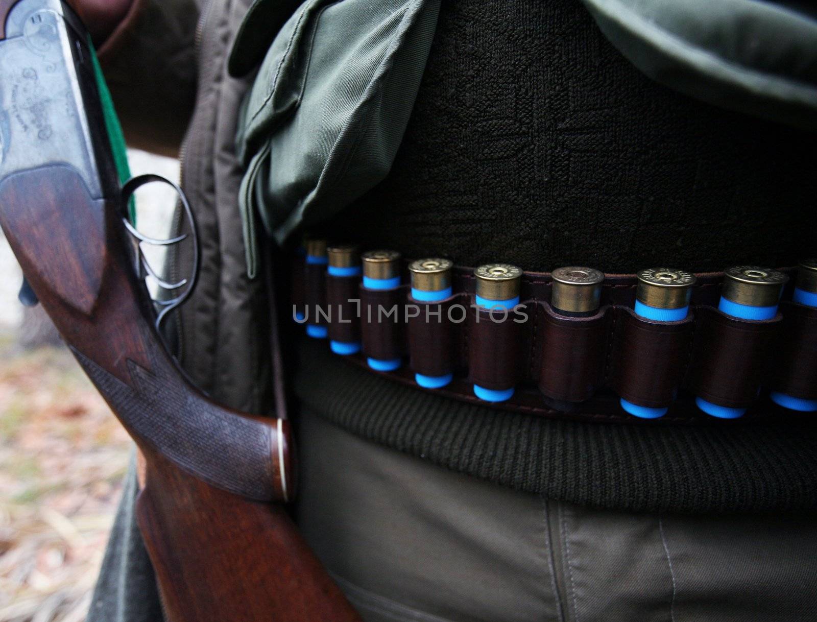 Hunter with ammunition belt around his waist and gun