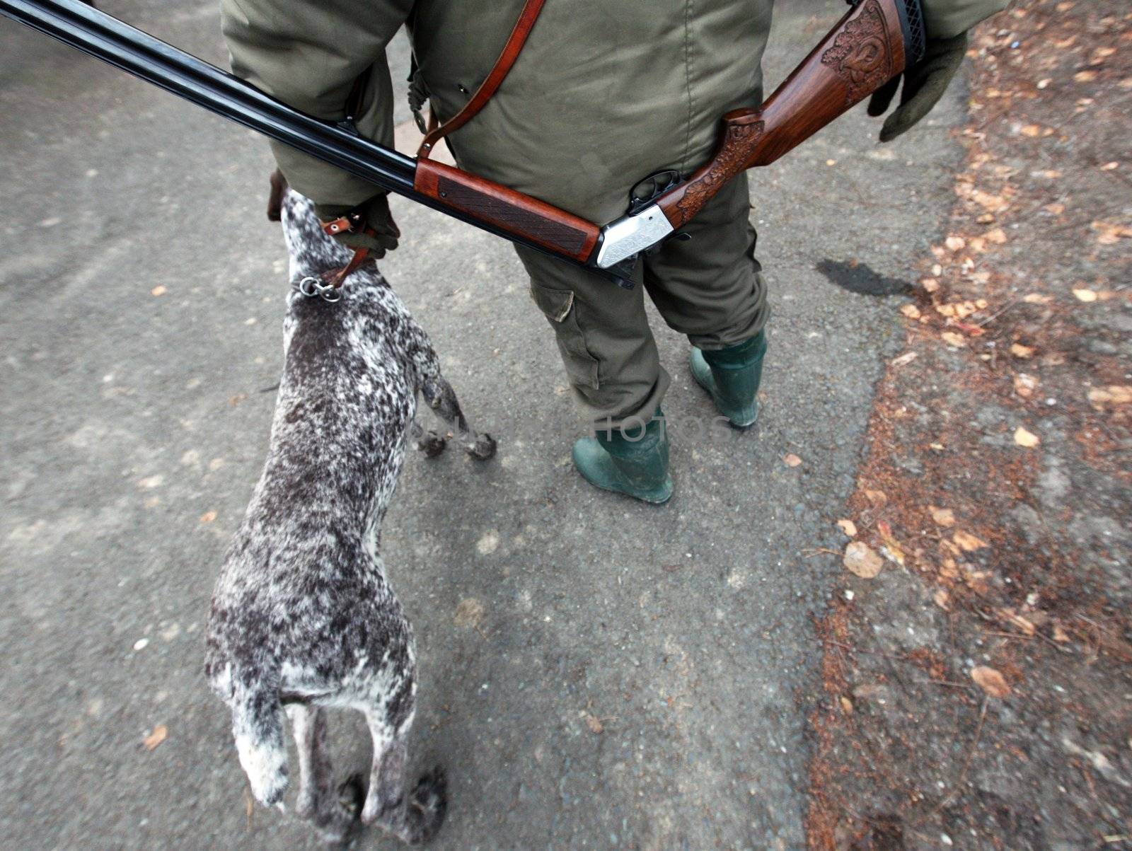 Hunter with gun on his back and his hunter dog