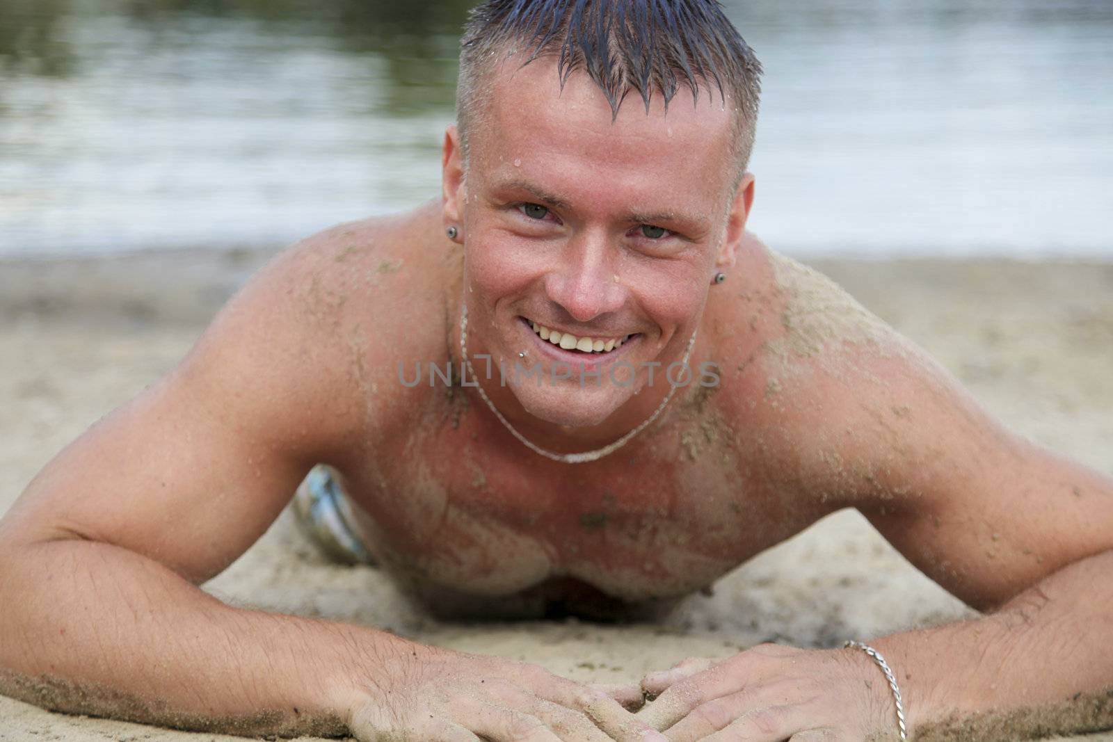 Cheerful Good Looking Man Having Fun In The Sand While Sunbathing